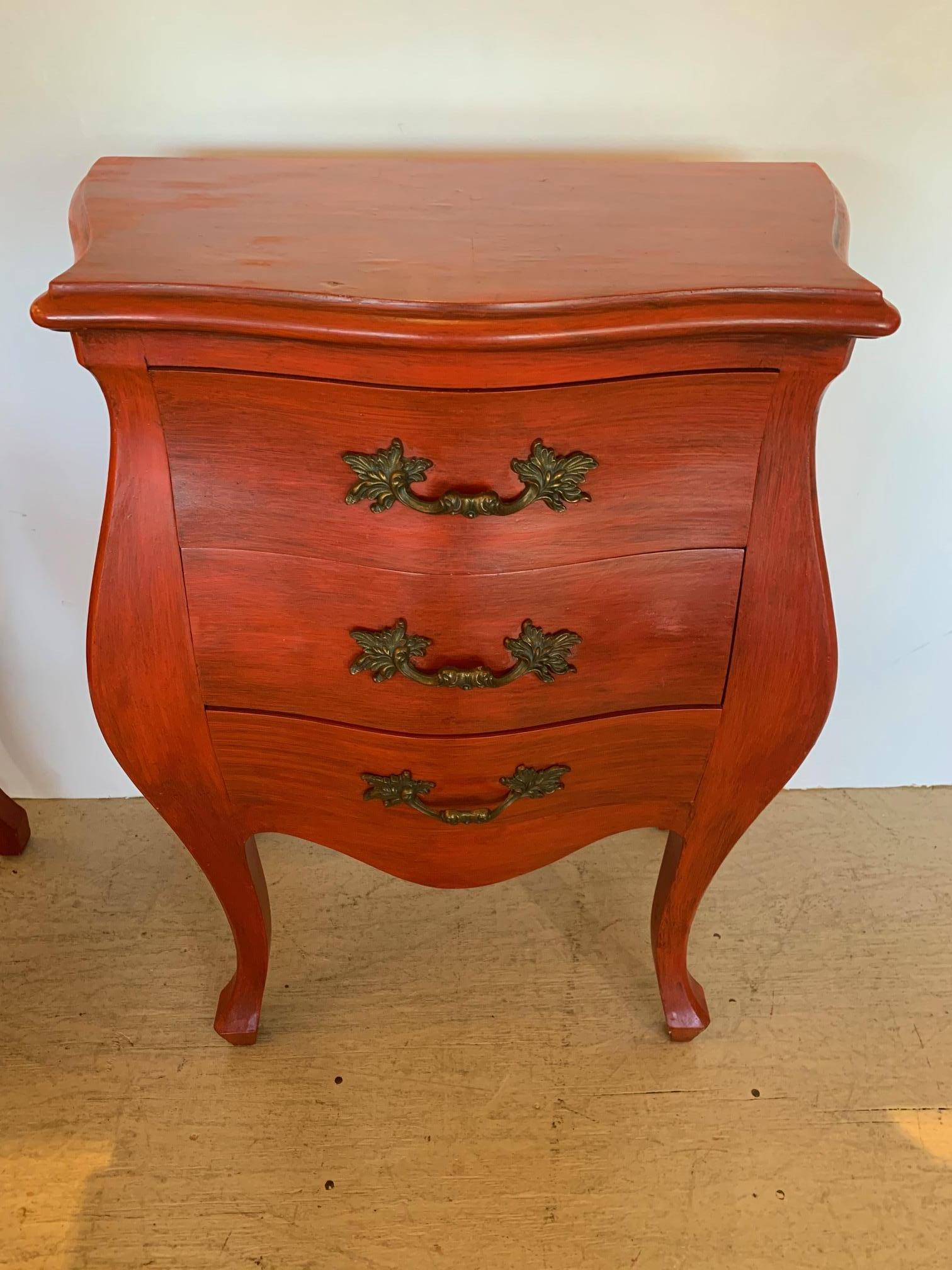 Stunning pair of French style Bombay shaped nightstands in a striking pumpkin color having 3 drawers, curvy cabriole legs and handsome bronze finish hardware.
