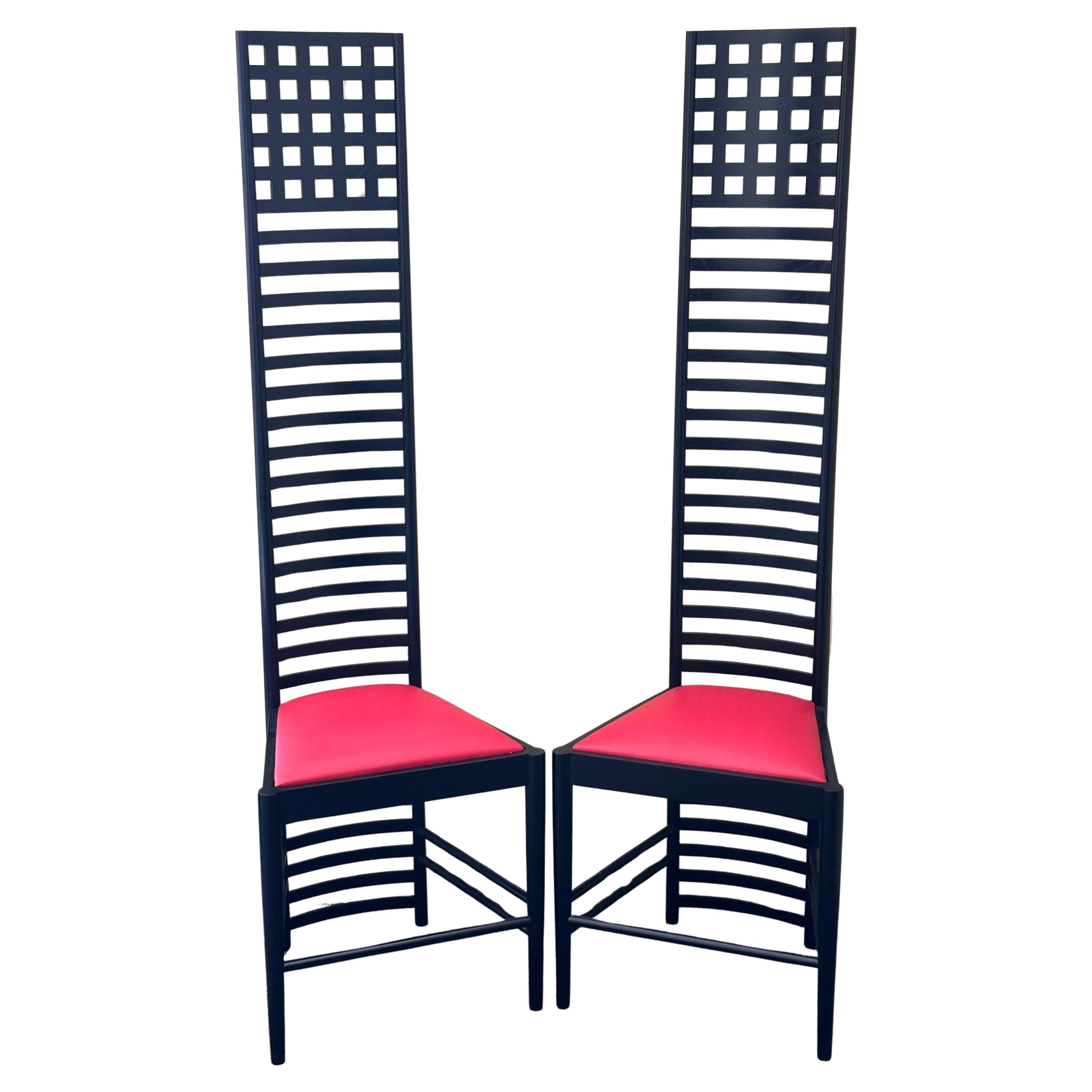 Rare pair of tall ladder back Hill House chairs designed by Charles Rennie Mackintosh, circa 1980's. The chairs have a black wooden base and super tall ladder backrest with red leather seat cushions.  The chairs are in like new condition and come
