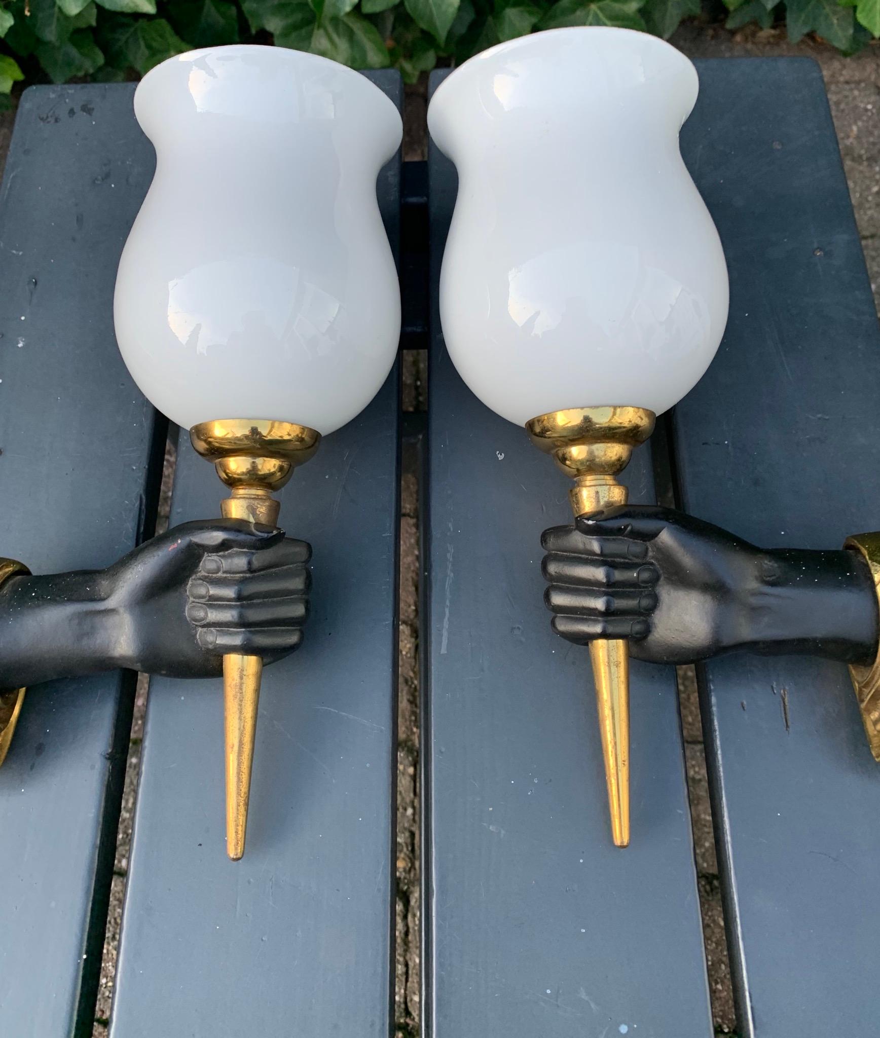 Midcentury hands - holding - torches wall lamps.

If you are looking for a small and decorative pair of wall sconces then look no further. These stylish and sought after, brass, bronze and iron wall sconces could make the perfect wall lights over