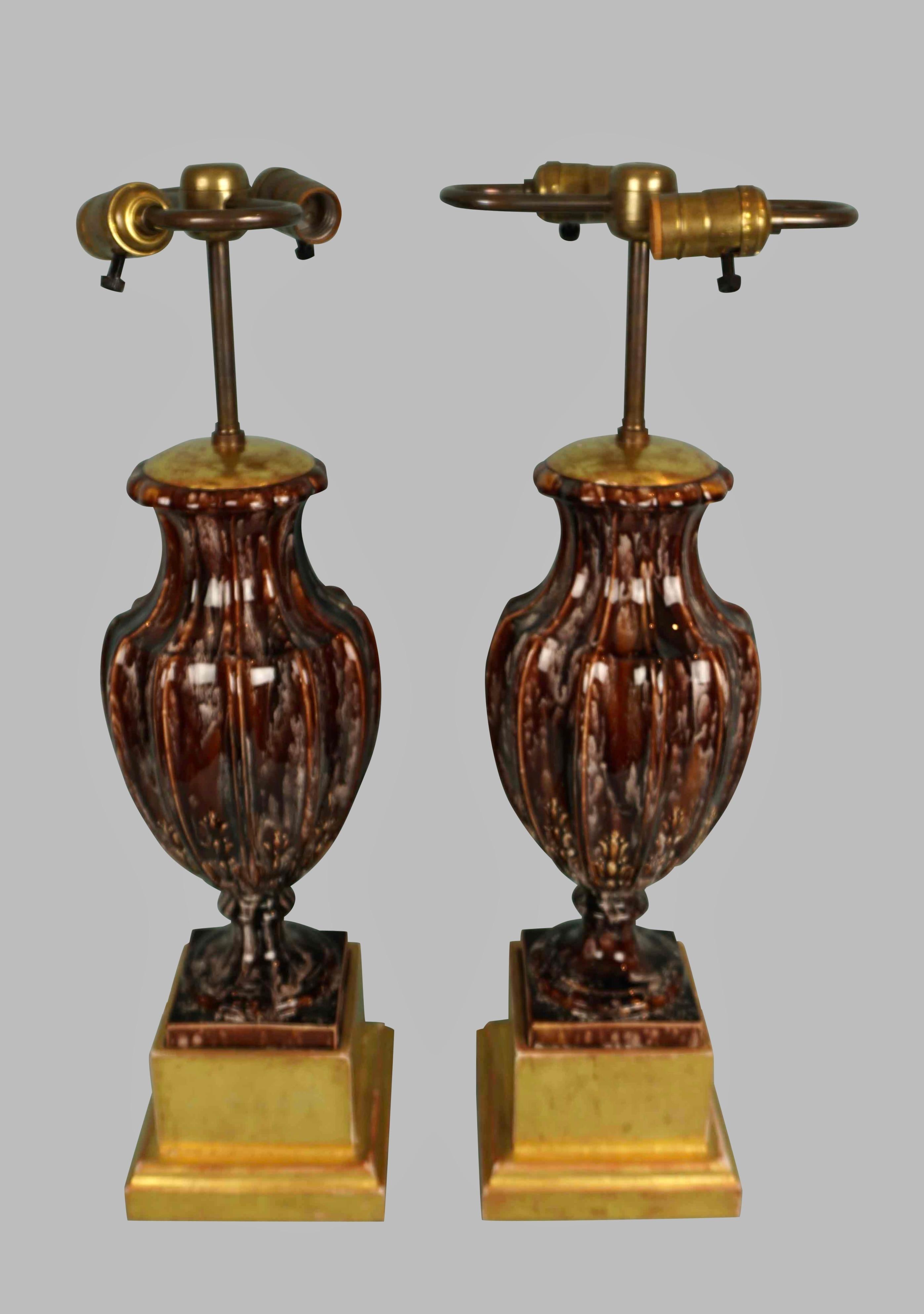 Ein attraktives und ungewöhnliches Paar brauner und cremefarbener Porzellan- oder Steingutvasen im neoklassischen Stil mit eingeritzten Details, die jetzt elektrifiziert und auf vergoldeten Sockeln montiert sind. Wahrscheinlich im ersten Viertel des