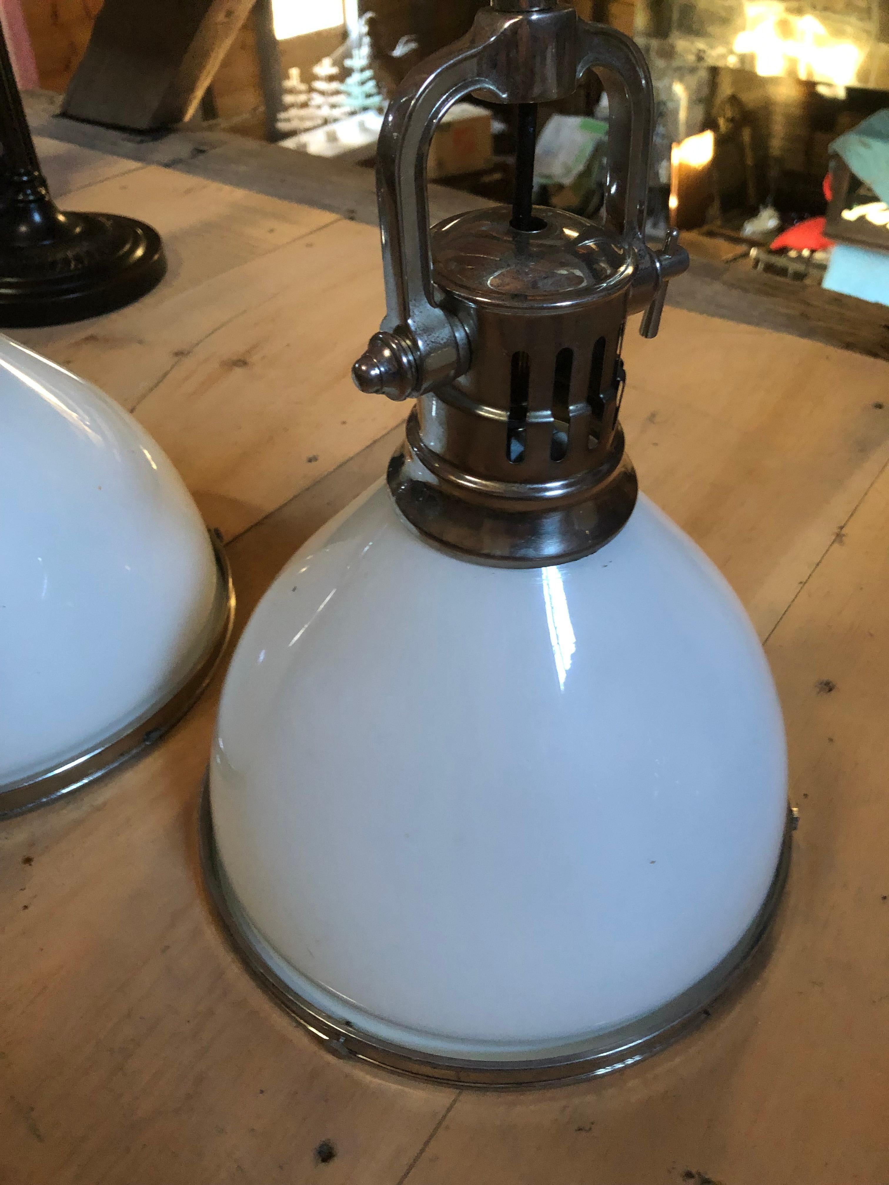 Striking pair of Hudson Valley Lighting single light medium sized industrial pendants having chrome stems and white opaque glass shades, closed at the bottoms with chrome ring frames.
Note: There are 3 very large matching pendants available.