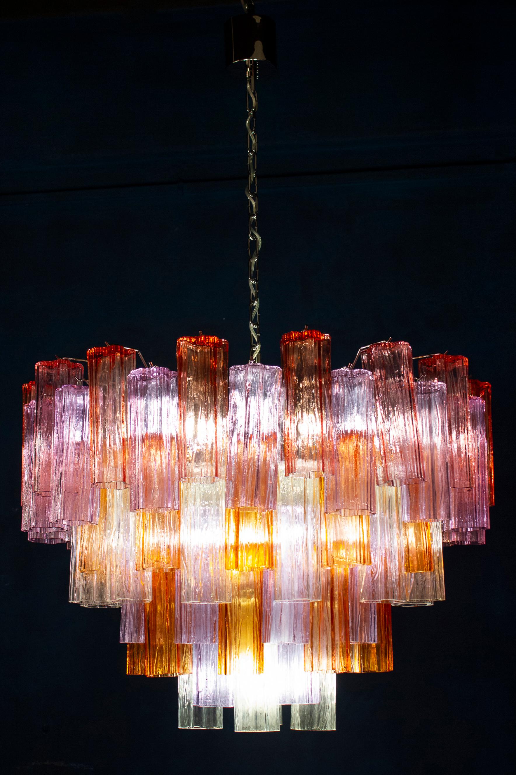 Coppia di sorprendenti lampadari con una rara combinazione di colori, vista l'unicità dei preziosi vetri di Murano color ambra, rosa, ametista e ghiaccio. Ogni lampadario è composto da 78 elementi tronchi in vetro soffiato sostenuti da una struttura