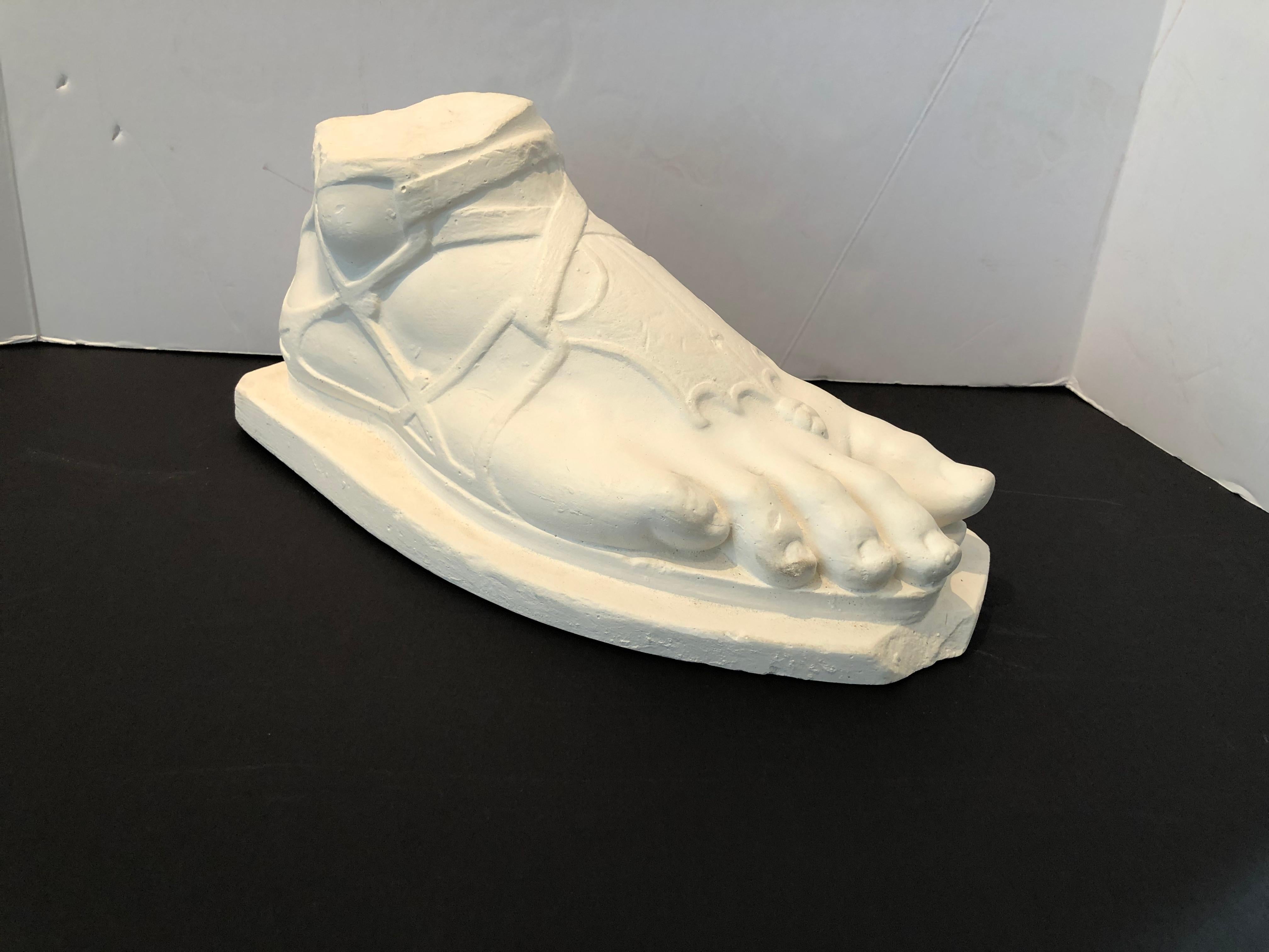 A plaster cast sculpture of the foot of Hermès, after the antique, signed on the side “D Brucciani & Co London