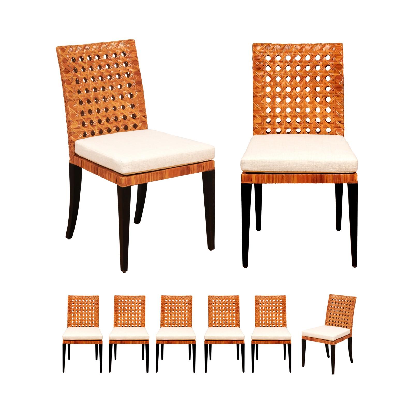 A stellar set of eight (8) elegant Organic cane side chairs. Stout solid mahogany frame construction painstakingly veneered in hand-wrapped open French cane. Contrasting legs executed in dramatic black lacquer. The cane displays a rich warm Caramel