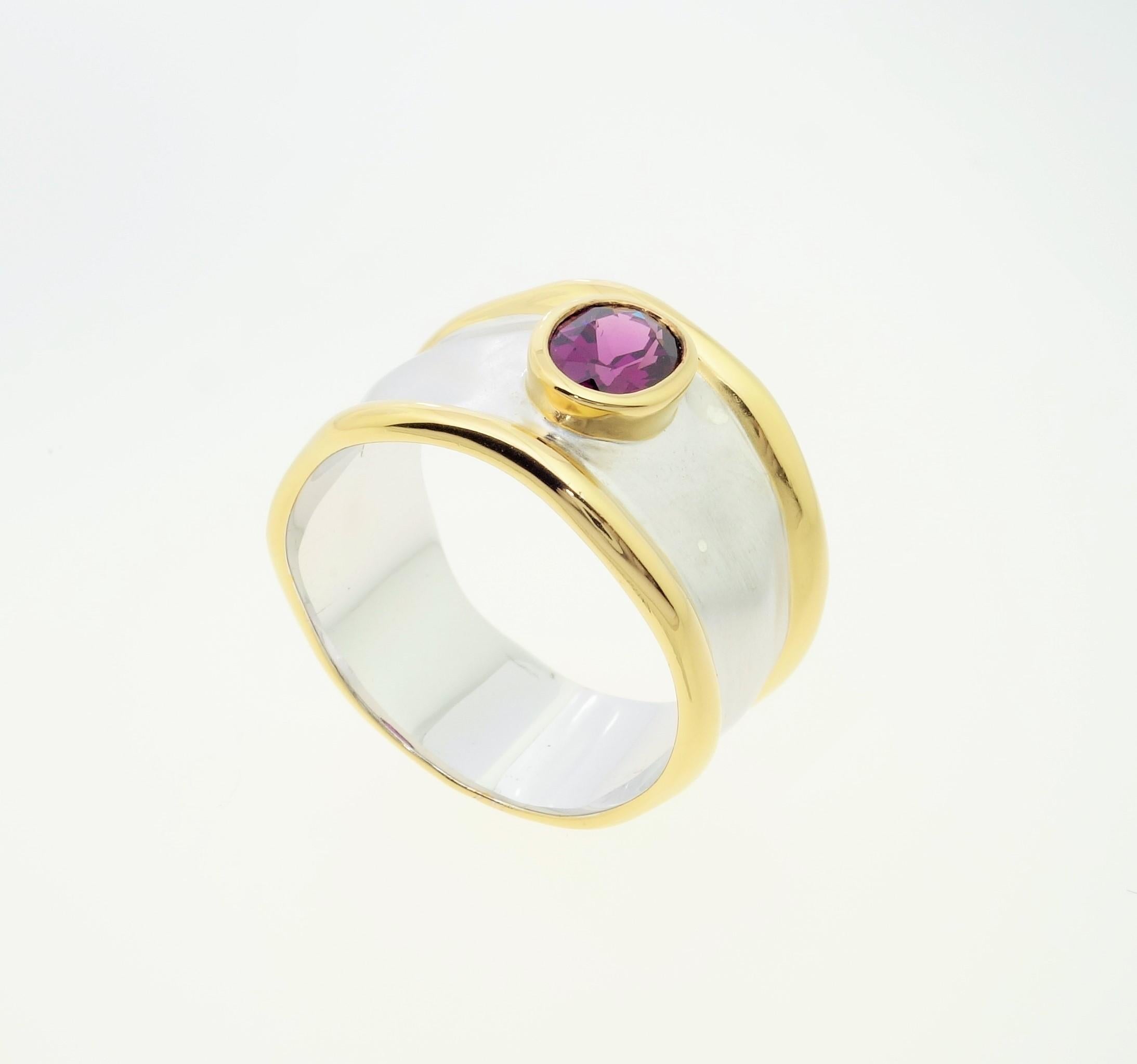 Beautiful solitaire Cocktail ring featuring an oval Rhodolite Garnet; approx. 0.78 carat; approx. stone size: 6mm x 5 mm. Sterling Silver Tarnish-resistant Rhodium and gold plated accents on either side of mounting; Size 8. Classic and