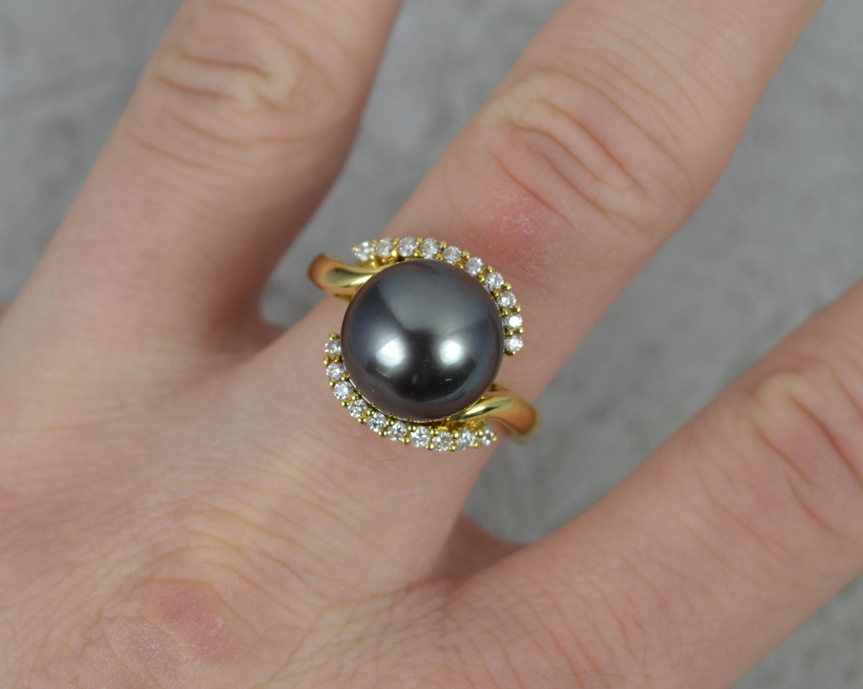 A superb Pearl and Diamond cluster ring.
Solid 18 carat yellow gold example.
Designed with a large Tahitian pearl to centre, 12.1mm diameter. 
Set with ten natural round brilliant cut diamonds above and below on a twist.
17mm spread of stones. 15mm