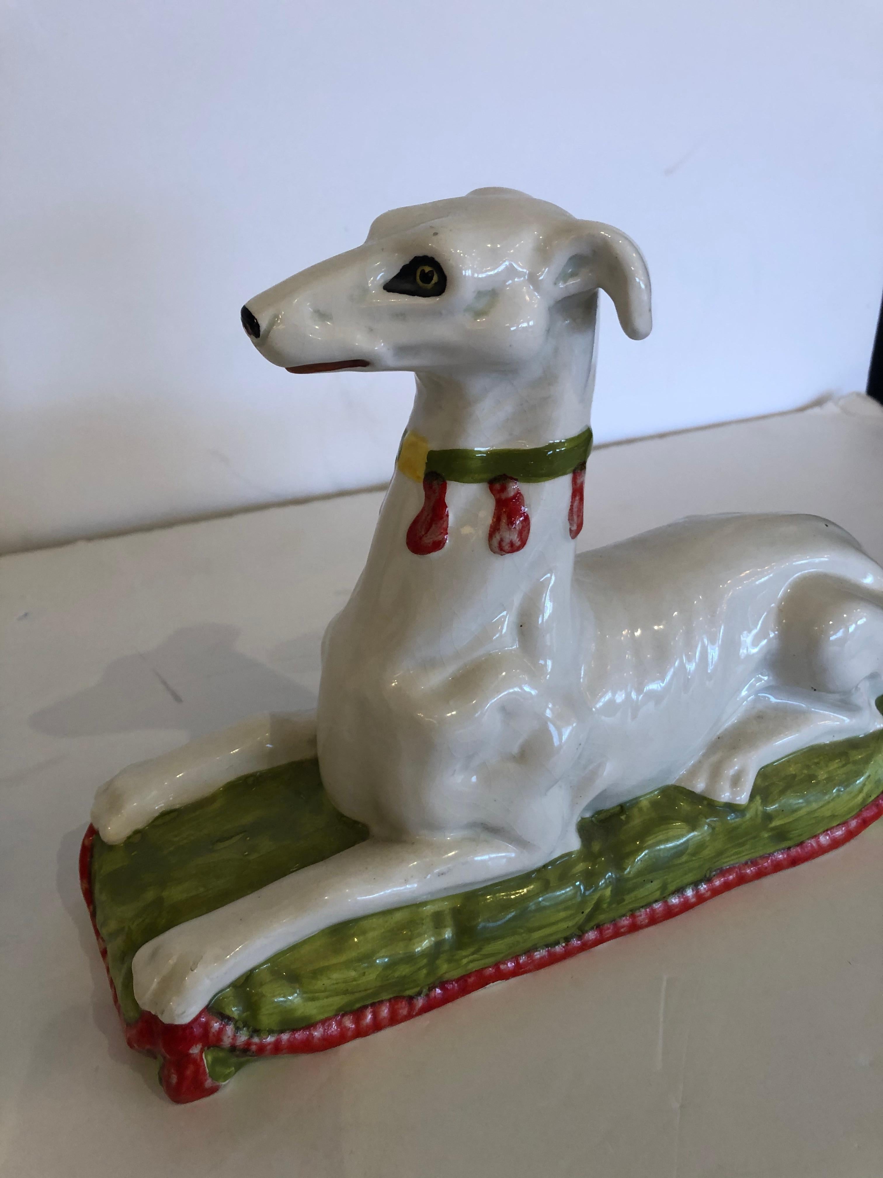 Wonderful eye-catching pair of Italian ceramic whippets regally posed and in a striking color palette of white, orange and green.