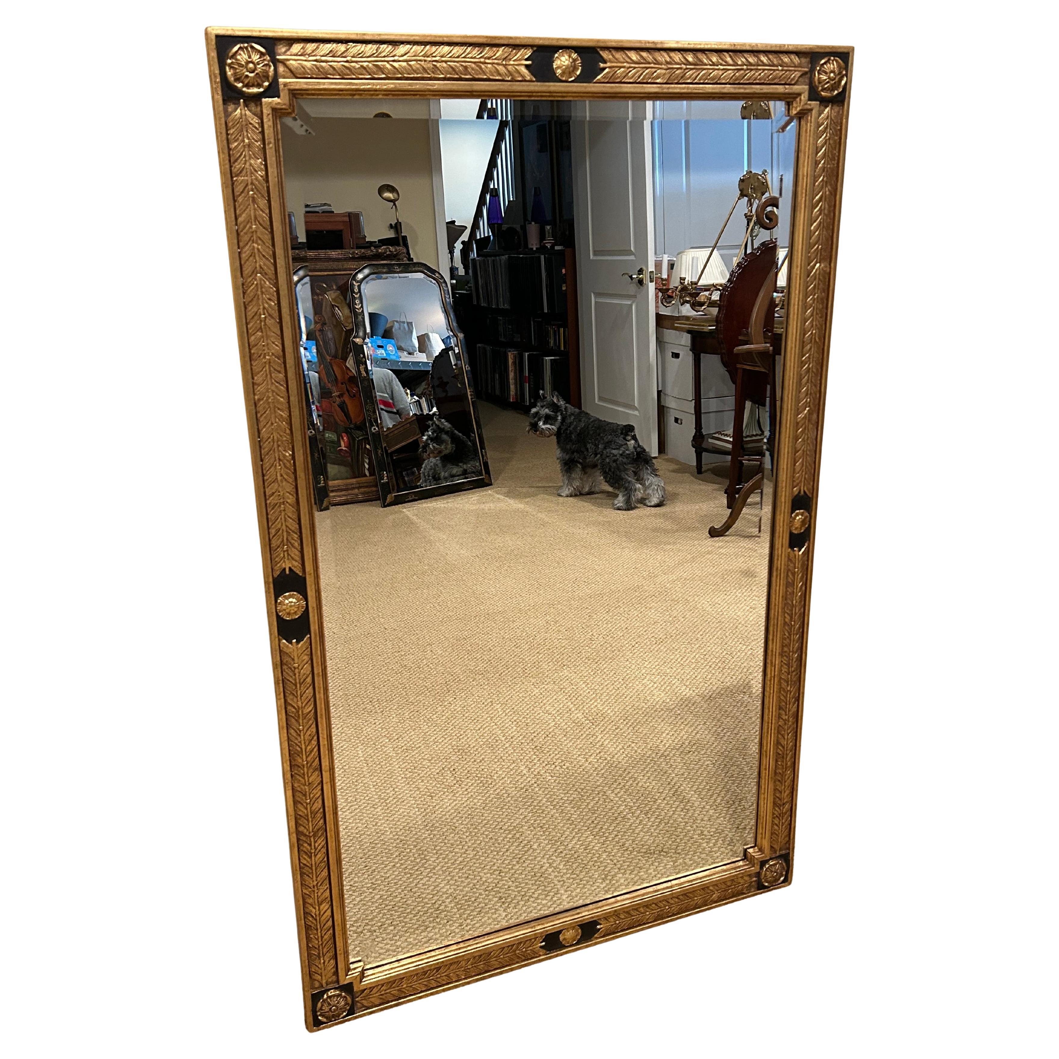 Eye catching beautiful large rectangular gold leaf and ebonized wood mirror having feather motif in the carved molding, with lovely decorative rosettes.