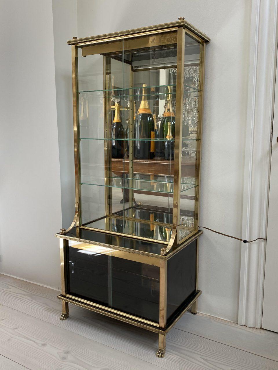 Handsome and striking vintage showcase, in the most beautiful condition with fine brass detailing – a little nod to Maison Jansen’s style. The gorgeous cabinet consists of an upper display section with sliding doors. Behind the sliding doors there