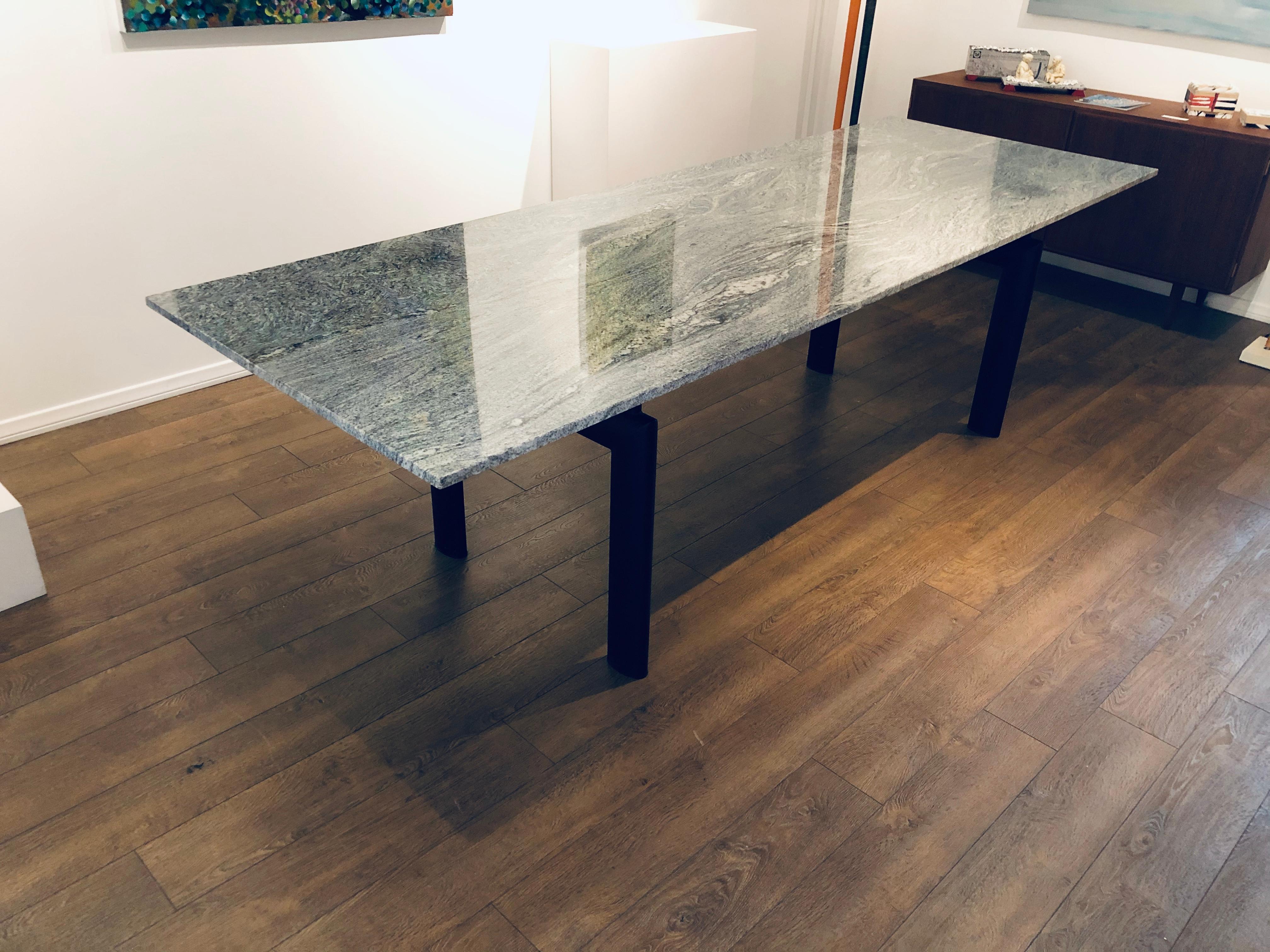 One of a kind striking extra large dining table with solid granite top and metal base, this table can seat up to 12 people, its minimalistic look, fits in every space. The grain on this granite its beautiful solid and no chips or cracks.