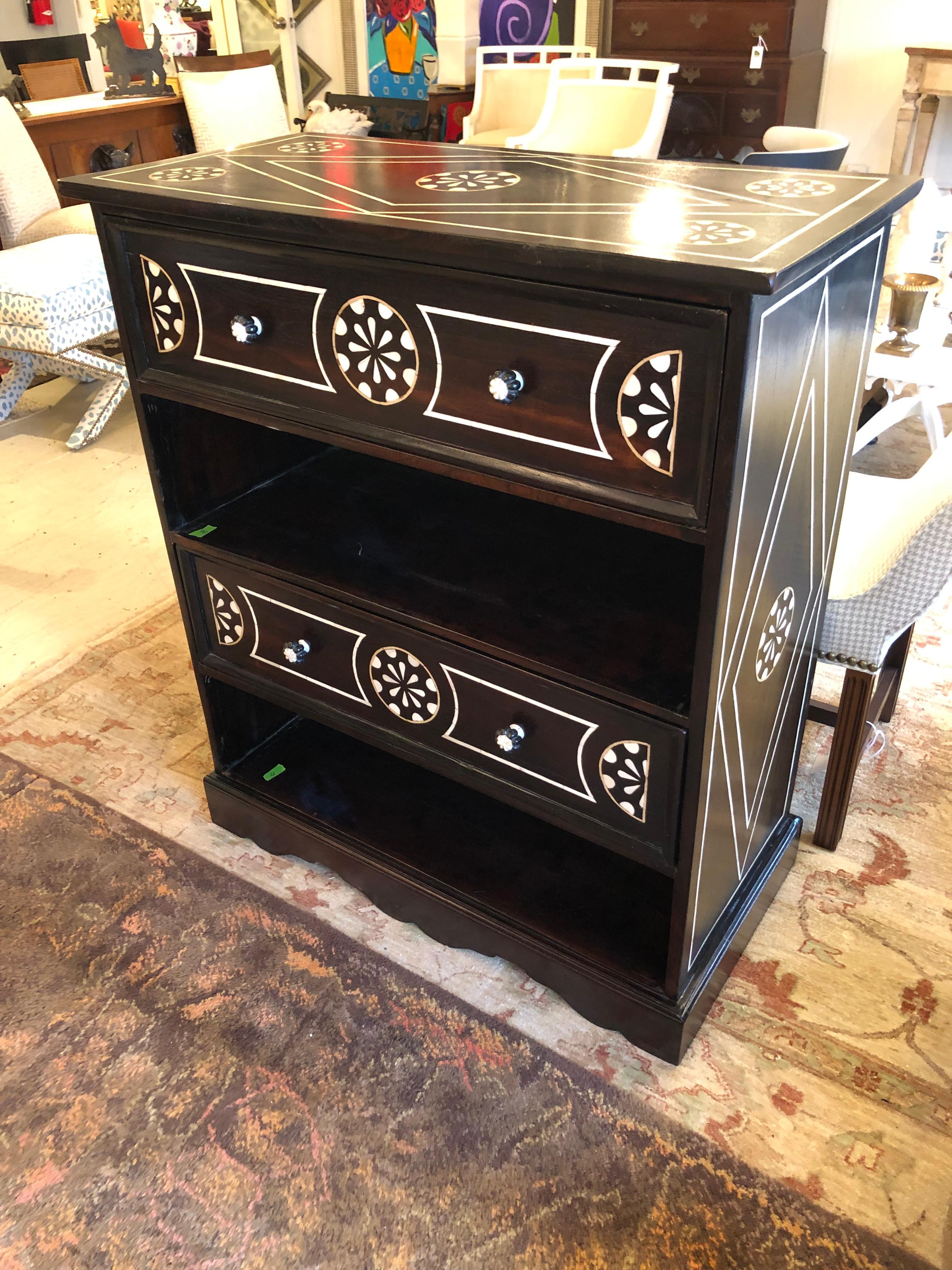 Magnificent strikingly graphic black and white dresser having ebonized wood with some areas of wood grain visible and white flower-esque inlay decoration.  Knobs are lovely decorative black and white gems.