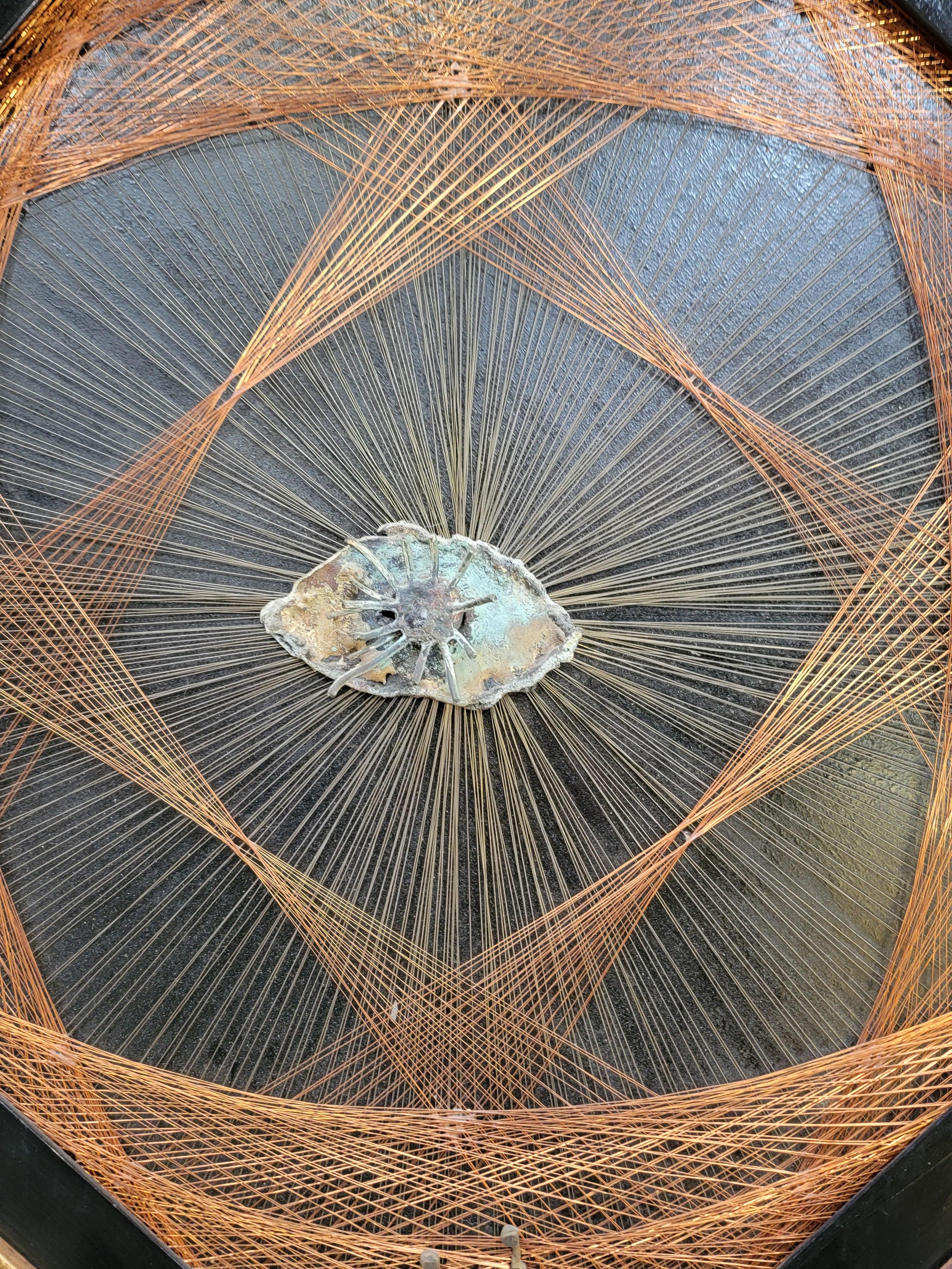 I've seen string art of the 1970's made of fishing line many times. But, have only seen copper and brass wire when I came across two of these amazing examples. Intricately crafted copper and brass wire woven within a diamond shape frame with black