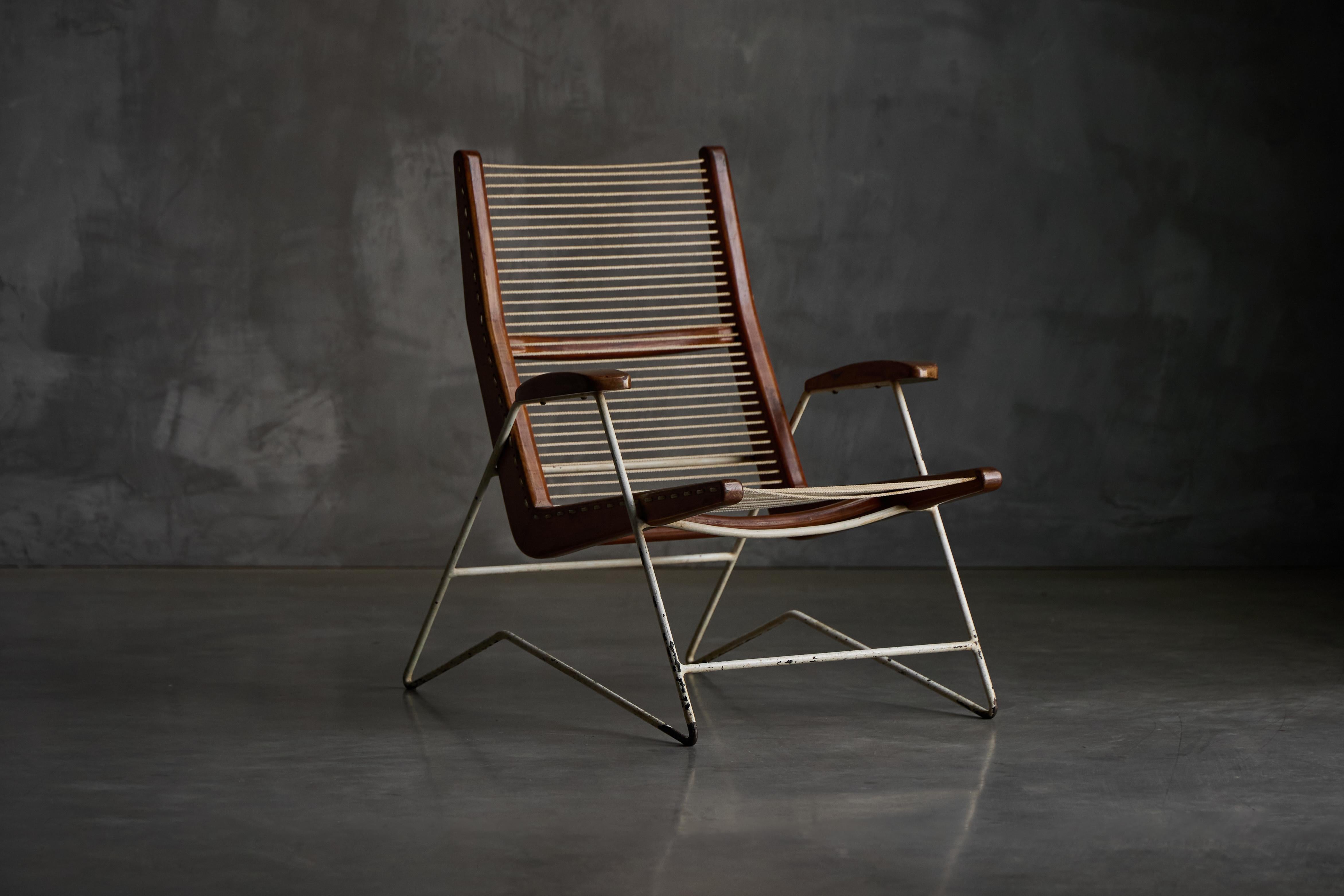 String Chair by Martin Eisler and Carlo Hauner,  showcasing their refined yet expressive design language. Its frame features slender, enameled metal legs and a sculptural, sloping silhouette. The seat and backrest are strung with taut cord, creating