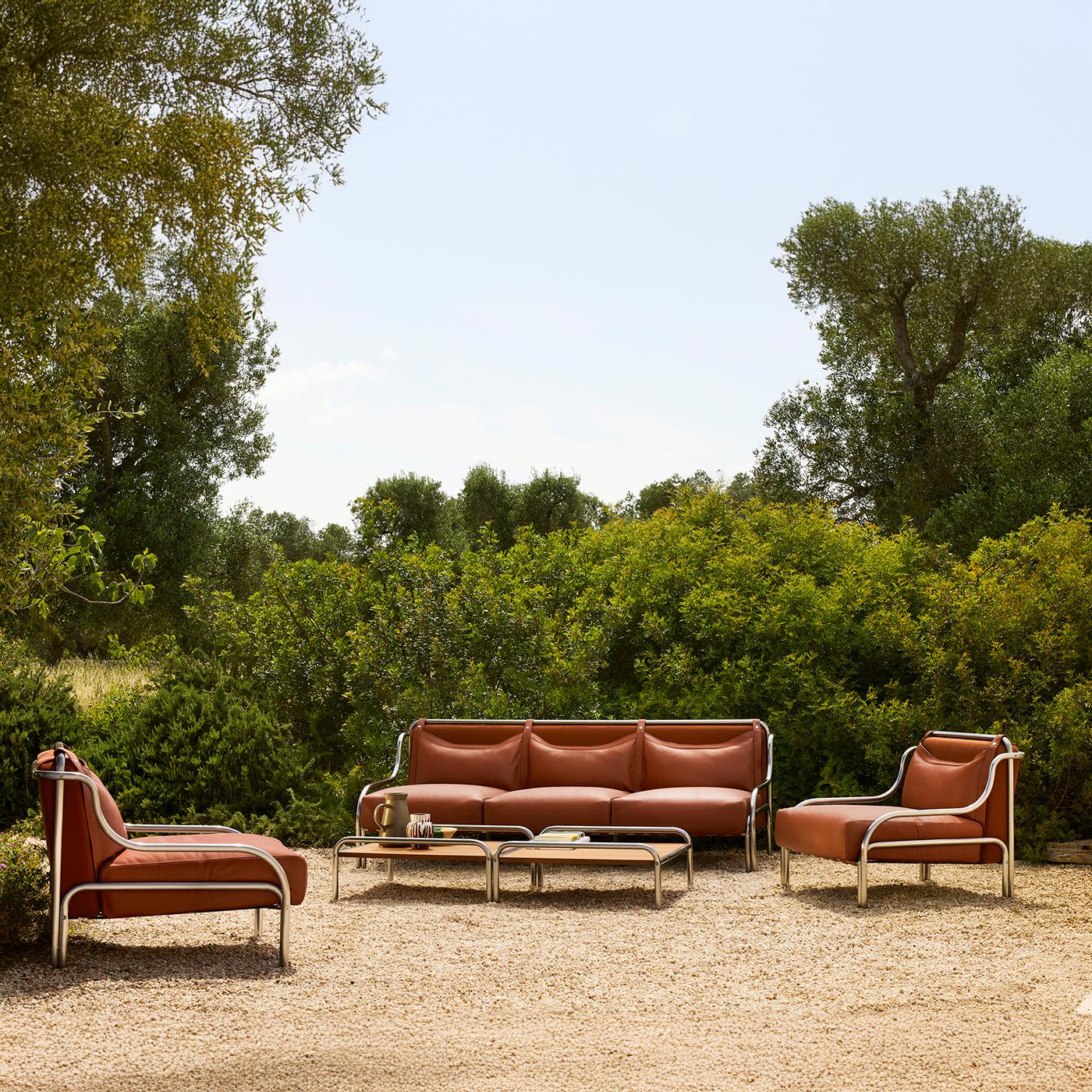 Distilling a refined and unmistakable '60s allure, this armchair is among the exclusive designs born from the brilliant pen of Gae Aulenti. Enveloping curves and a generous padding sealed by fine brown leather characterize the armchair, its