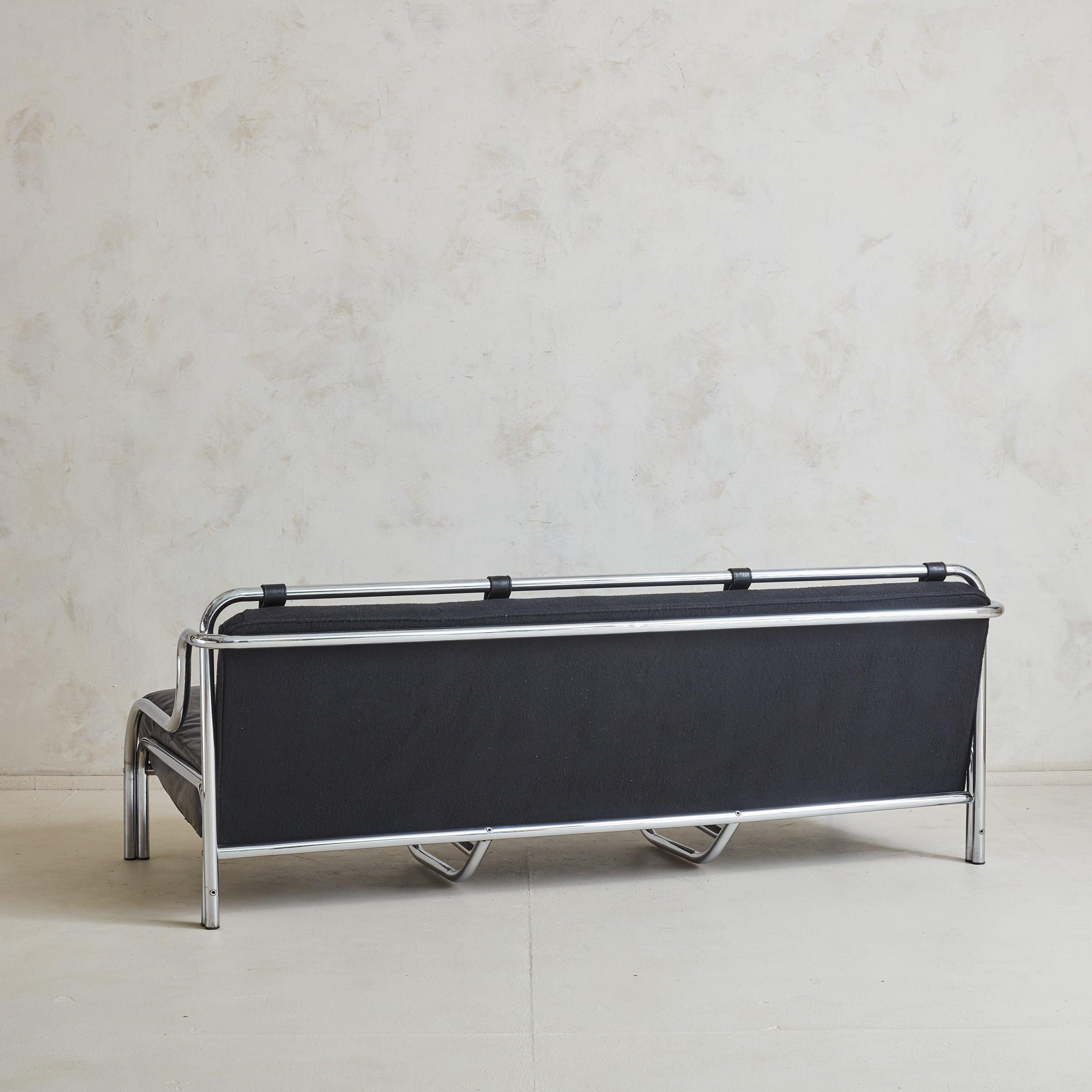 An iconic ‘Stringa’ three-seat sofa designed by Gae Aulenti for Poltronova in 1962. This beautifully proportioned, sculptural sofa is constructed of tubular chromed metal and features patinated black leather seat cushions. The padded back cushions