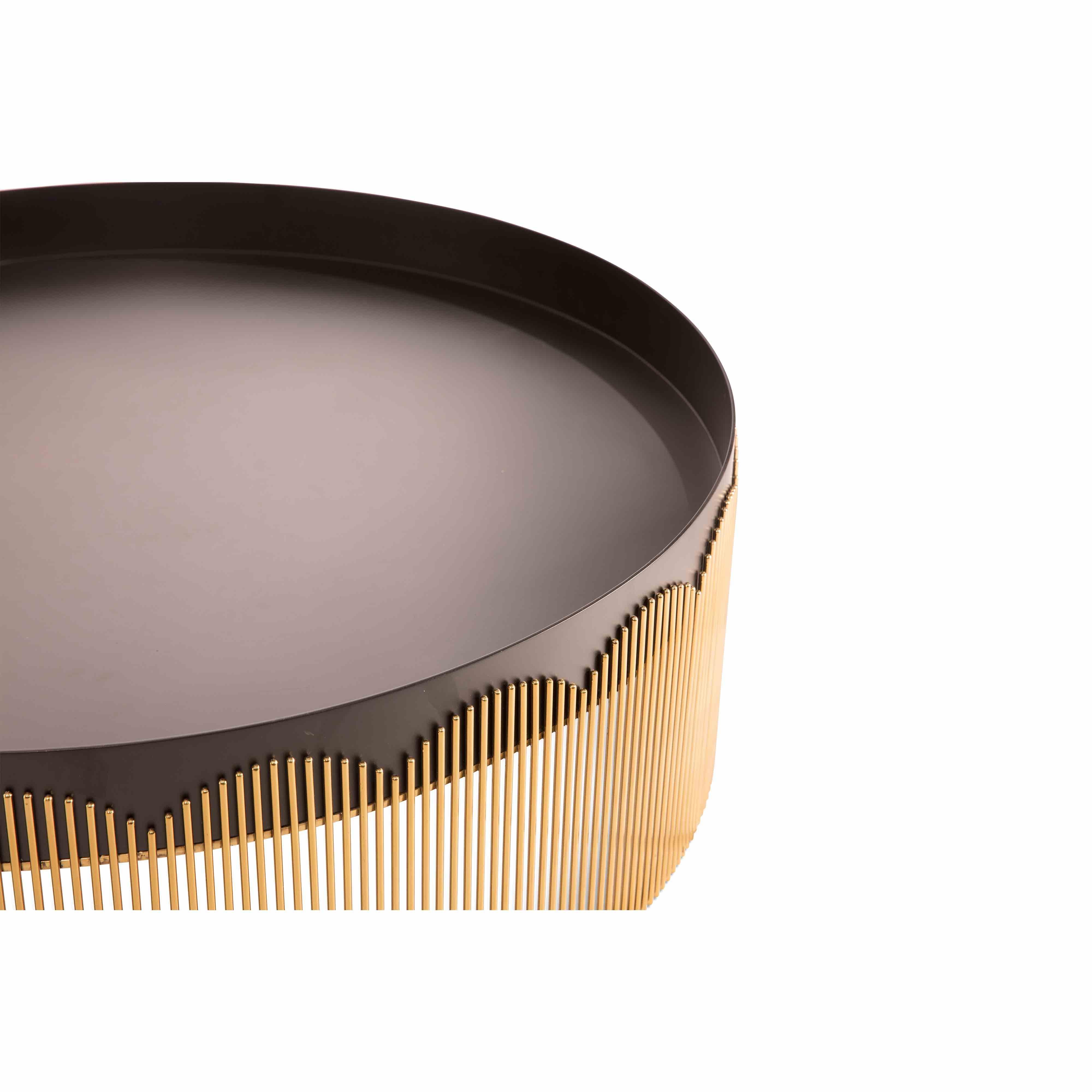 Strings gold and black metal coffee table by Nika Zupanc, is elegant in its lace-like gold, steel base with matt black tray top.

The word strings evokes a vision of lightness in our minds. Be it the strings of a musical instrument or textile