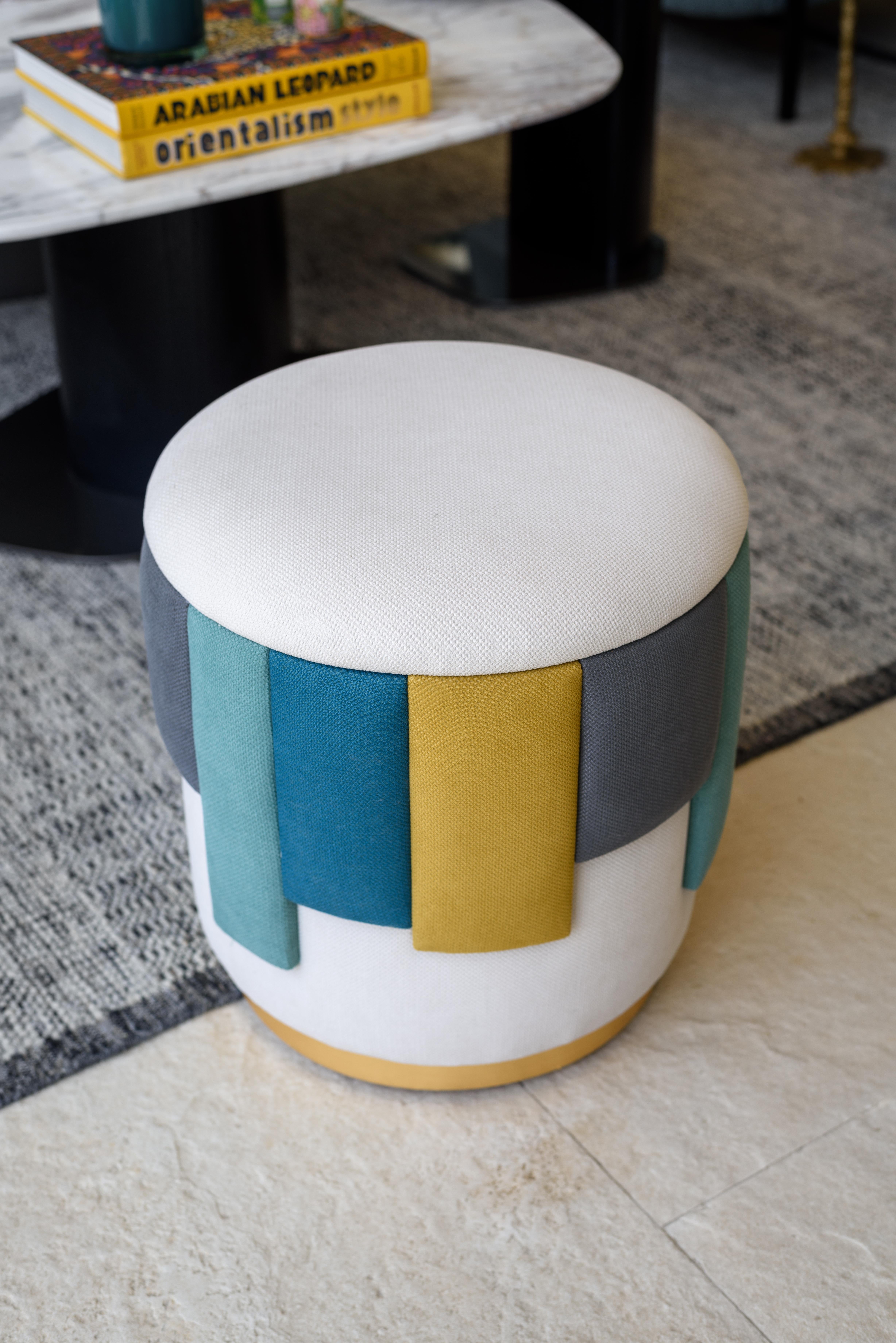 El puf de tiras es un asiento contemporáneo y divertido que combina comodidad y diseño moderno. Su forma cilíndrica está tapizada con una tela suave y texturizada en un color base neutro, complementada con una vibrante banda de tiras de tela