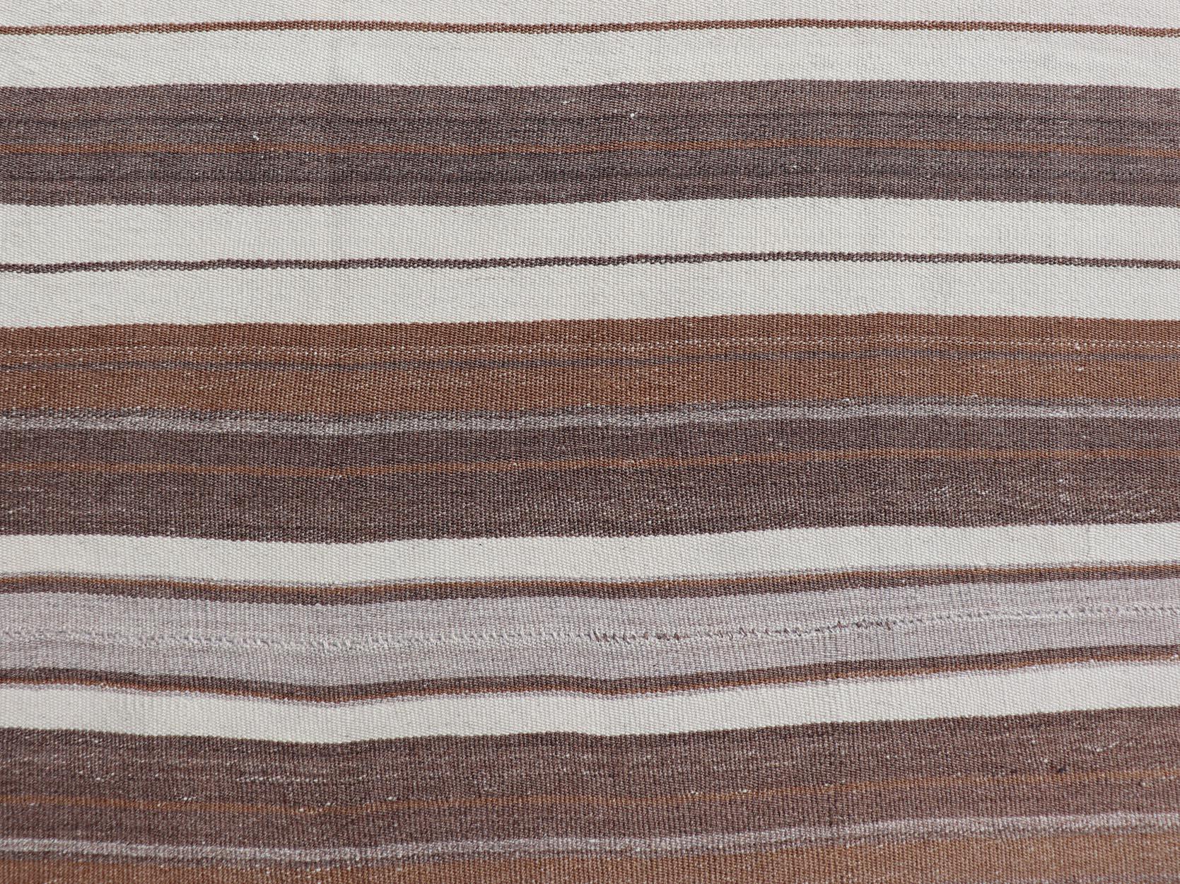 Shades of brown, cognac, tan, and ivory vintage Kilim from Turkey with Minimalist design in stripes. Keivan Woven Arts / rug EN-178651, country of origin / type: Turkey / Kilim, circa 1950

Measures: 4'4 x 6'0.