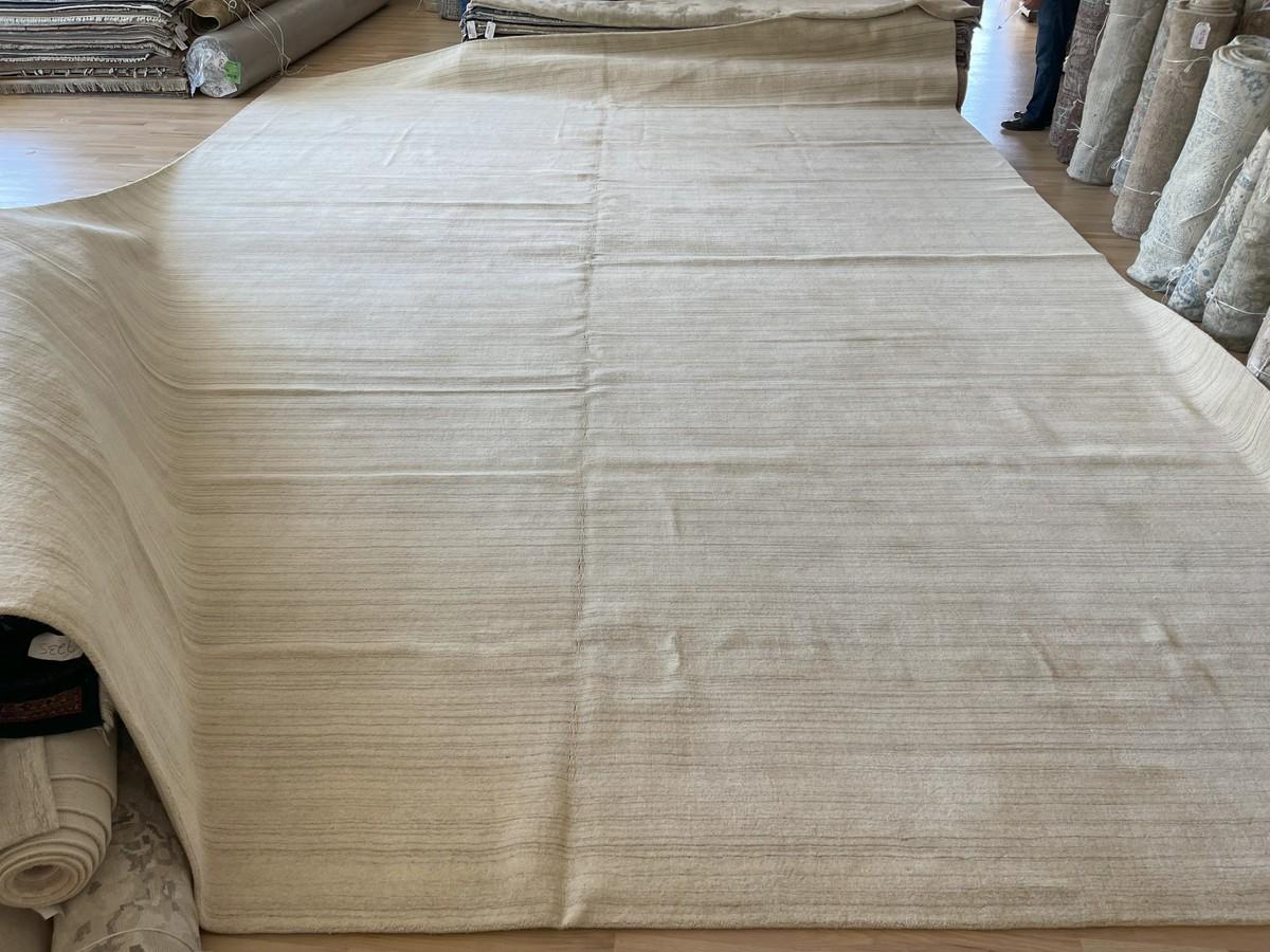 Klassisch und zeitlos ist das, was dieser gestreifte, einfarbig beige Teppich ausstrahlt. Dieser handgewebte, in Indien hergestellte Teppich verleiht Ihren Räumen eine besondere Eleganz. Sein schlichtes, aber strukturiertes Design macht es einfach,