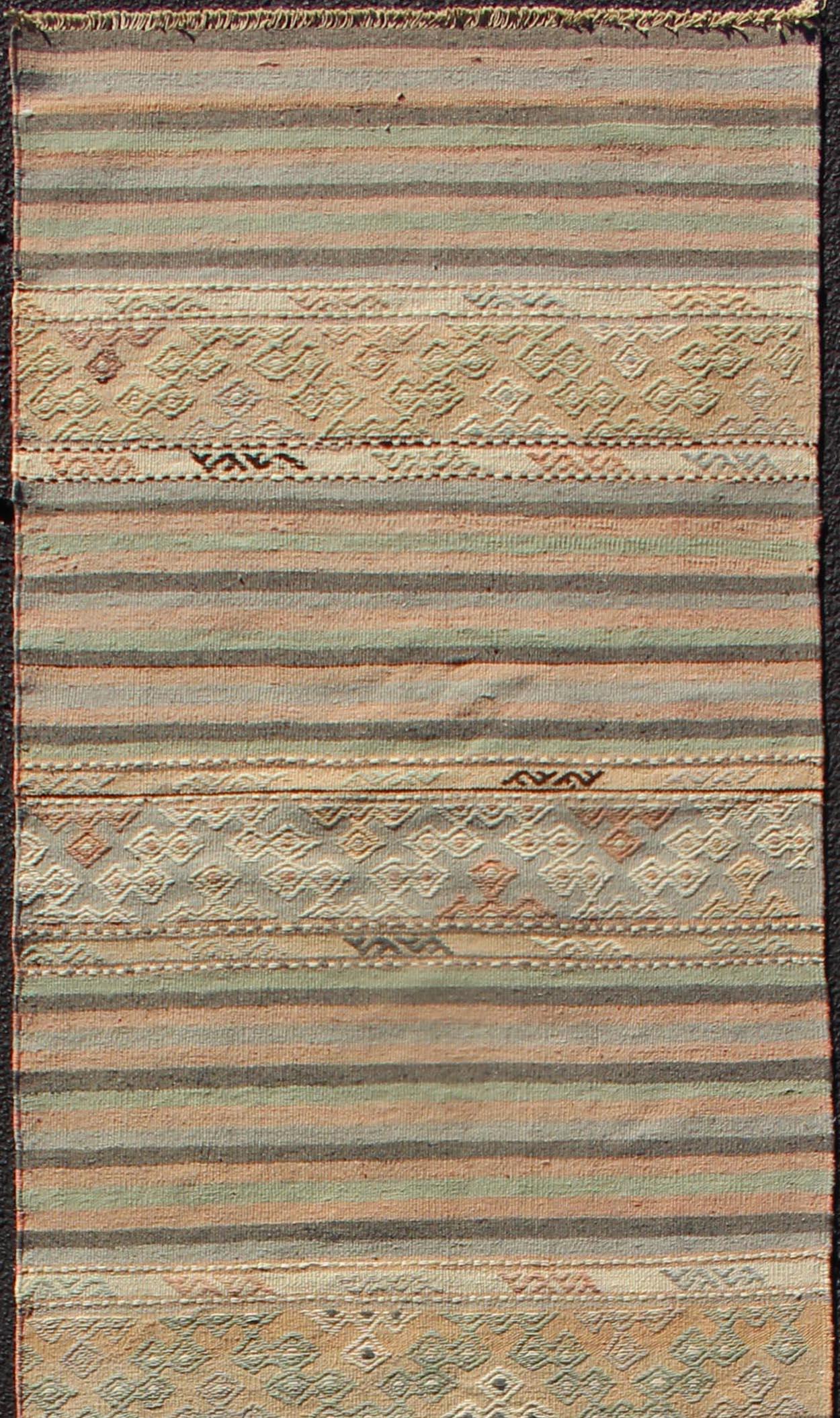 Turkish Kilim vintage carpet in green, tan, orange. Keivan Woven Arts / rug TU-NED-610, country of origin / type: Turkey / Kilim, circa 1950

This Kilim rug from Turkey features a striped design of various geometric patterns rendered in shades of