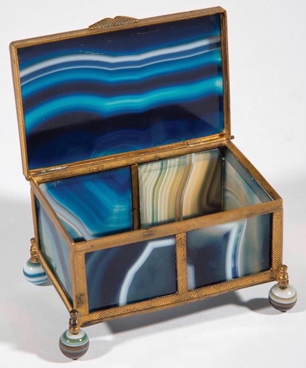 Bronze mounted striped blue agate box with striped agate ball feet and hinged lid.

 