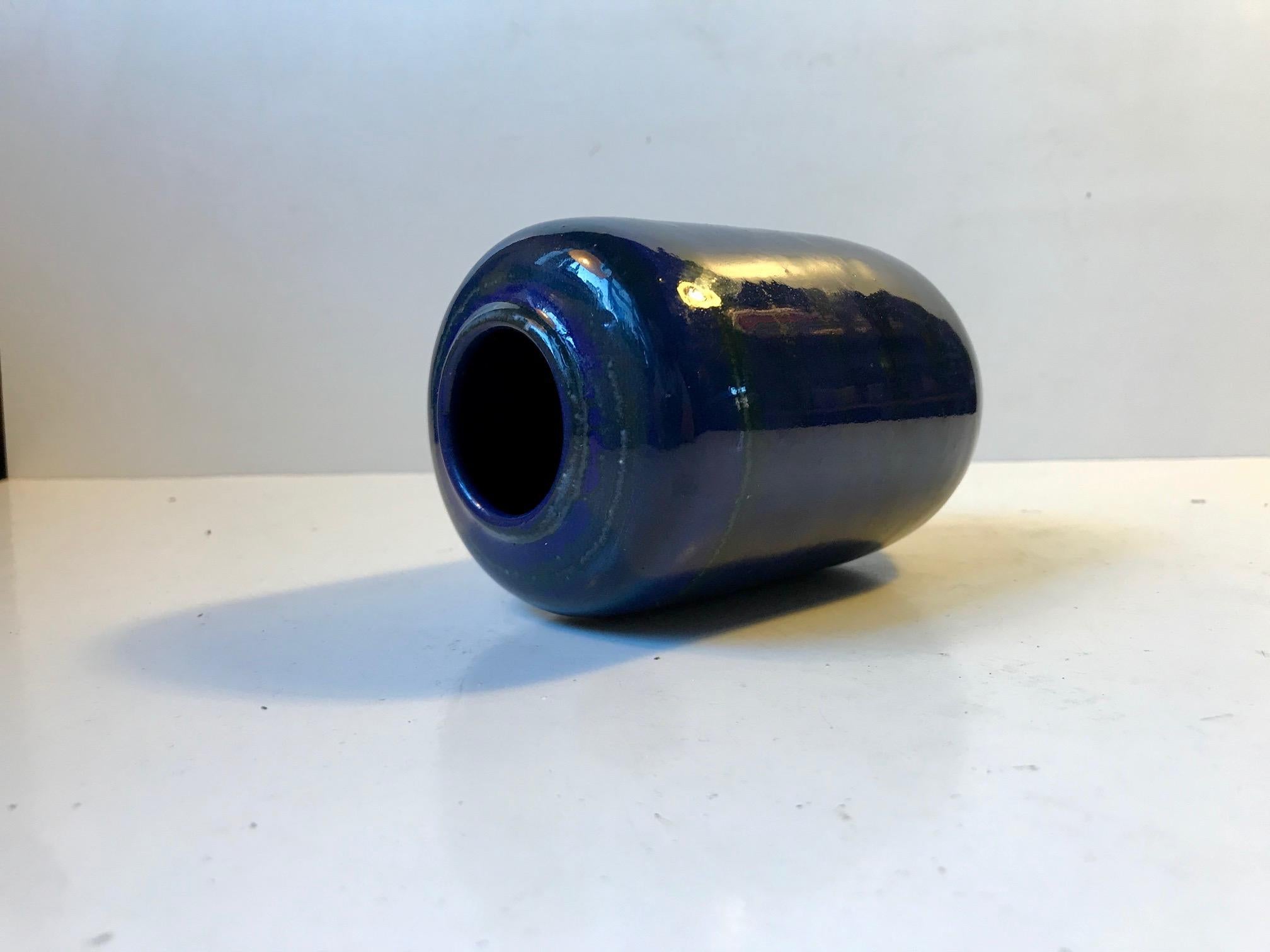 Organically shaped ceramic vase in blue glaze with green stripes. Designed by the German ceramist Gerhard Meisel and made in his studio in Stahnsdorf during the 1970s. Signed by hand to the base.