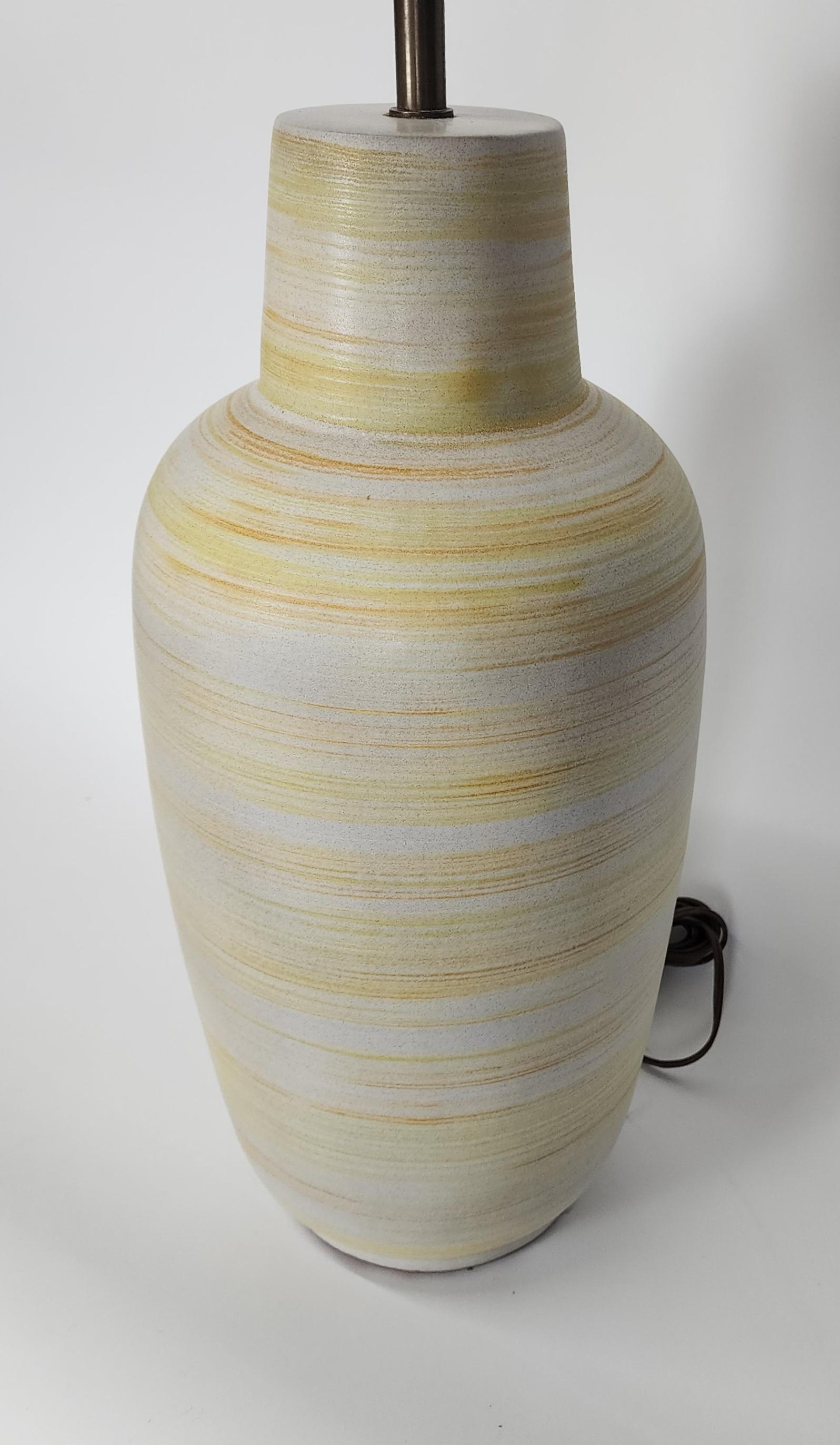Grande lampe de table en céramique mate jaune et blanche rayée, fabriquée à la main par Design/One. Whiting : la forme classique de la bouteille Design/One avec un tourbillon horizontal en jaune vif vibrant et de fins détails orange sur fond blanc.