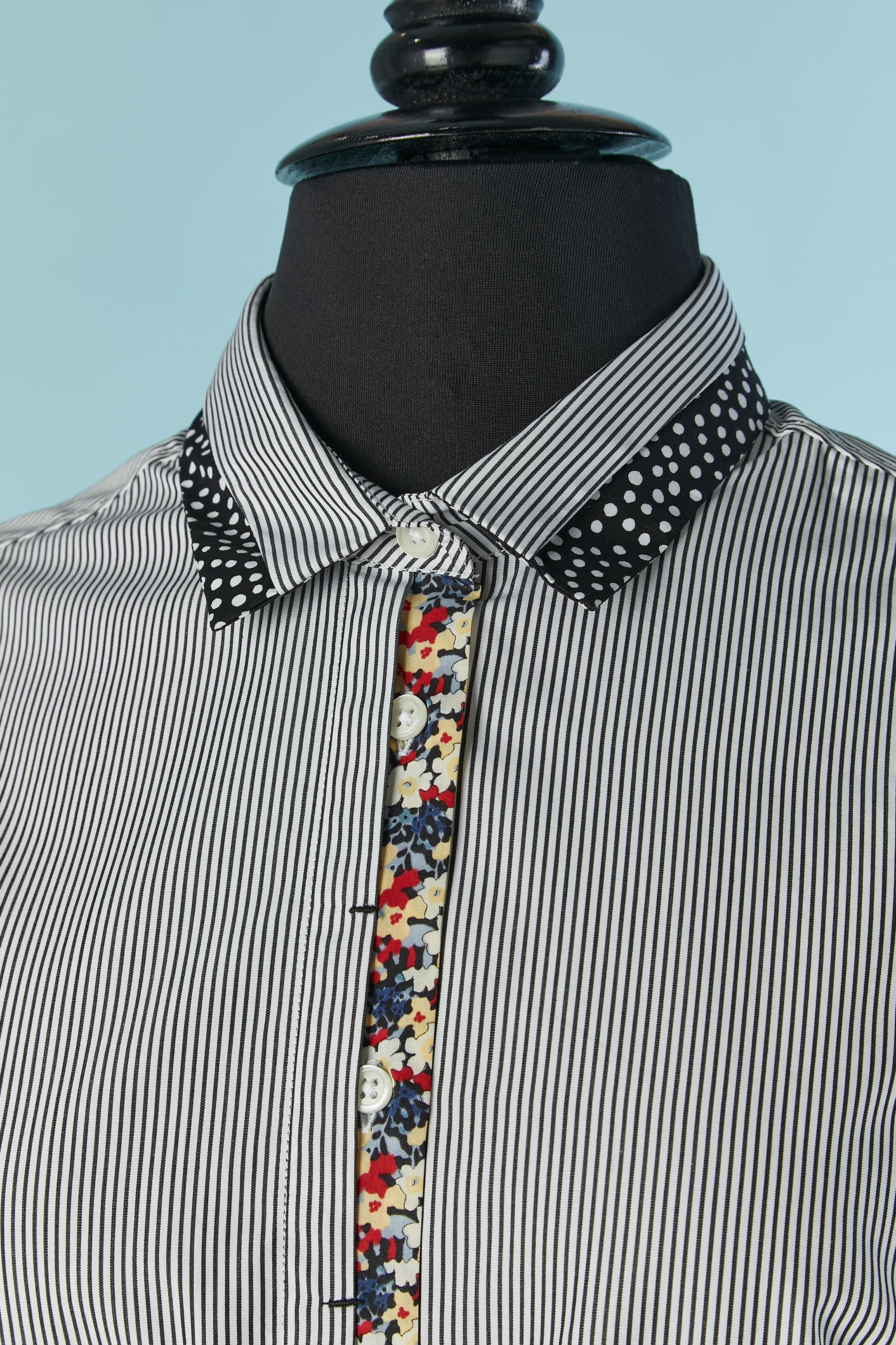 Gestreiftes Baumwollhemd mit Blumendruck und Tupfen-Details. Verdeckter Knopf- und Knopflochverschluss in der vorderen Mitte und am Ärmel. Eine zusätzliche Taste ist vorhanden. 
Ein Knopf und ein Knopfloch hinter dem Nacken. 
GRÖSSE S 