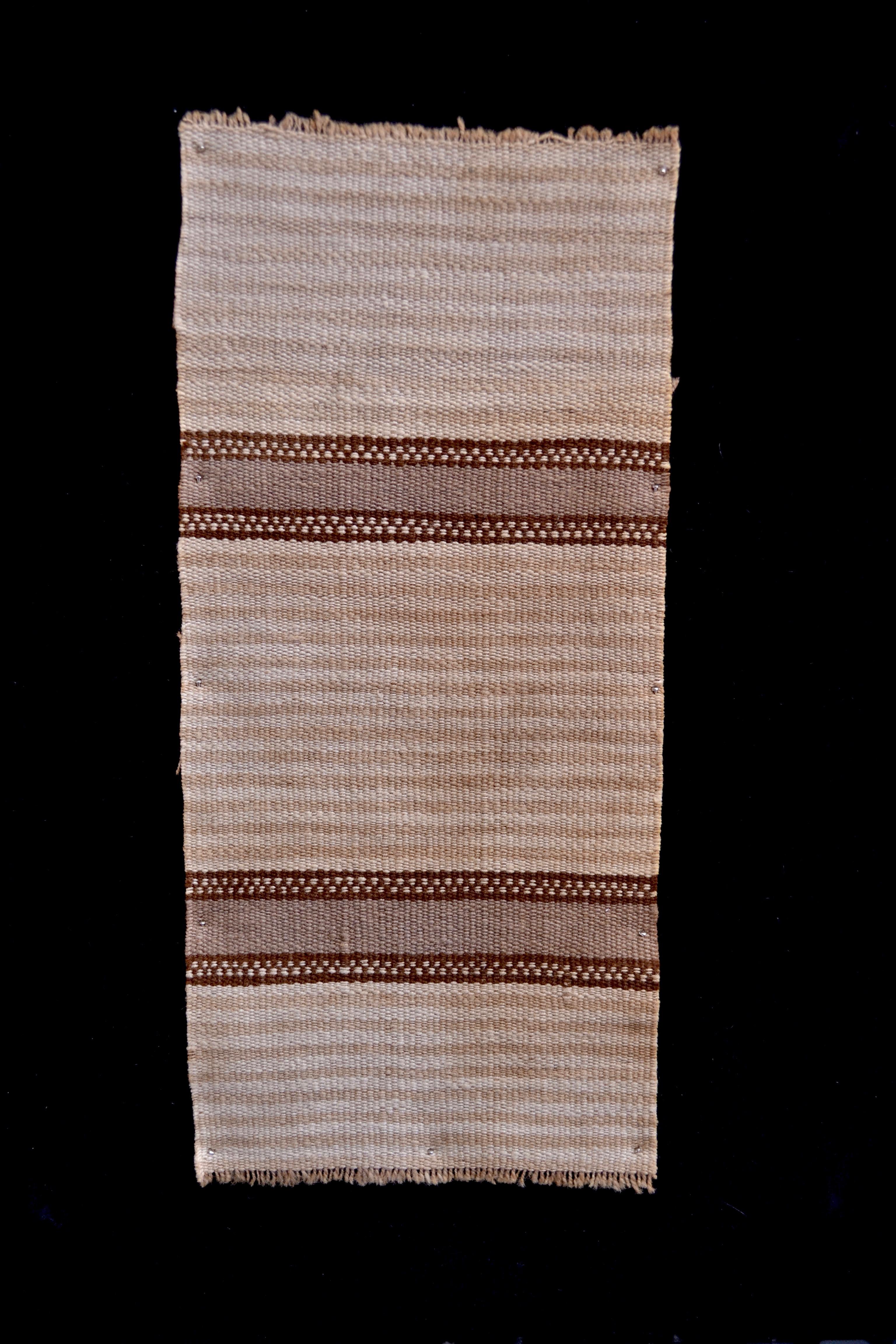 Earth tones adorn this striped pattern pre-Columbian textile. These piece is mounted on a black shadowbox frame. 

It is a wonder to behold antiquities such as a pre-Columbian textiles, an authentic piece of art that has been preserved for