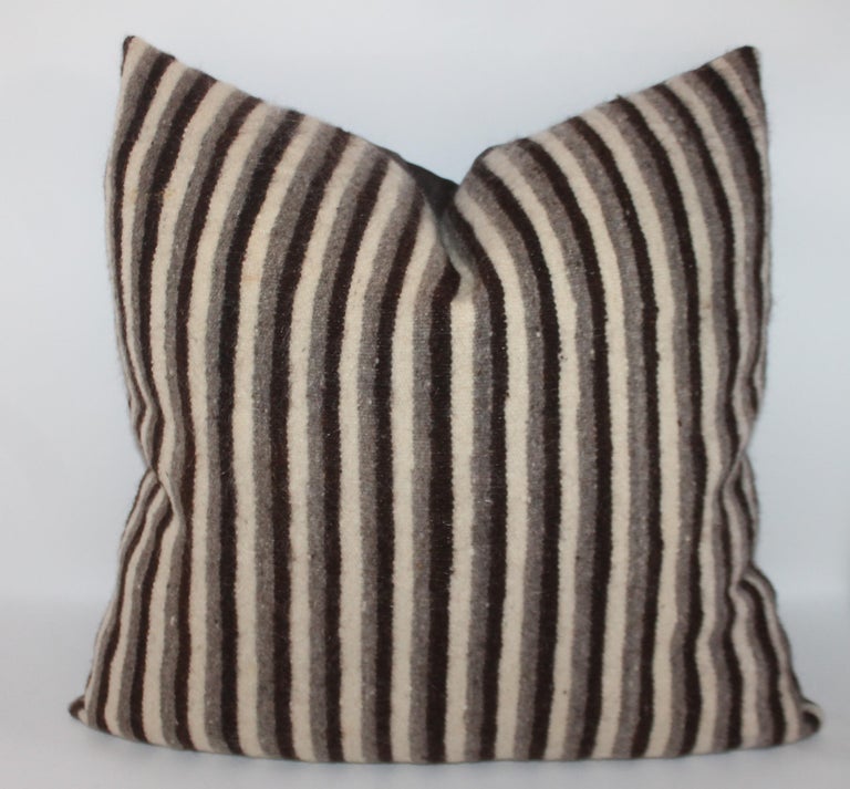 Set of three handwoven saddle blanket pillows. The colors are brown and cream. The backing is in a brown cotton linen. Inserts down and feather fill.
 