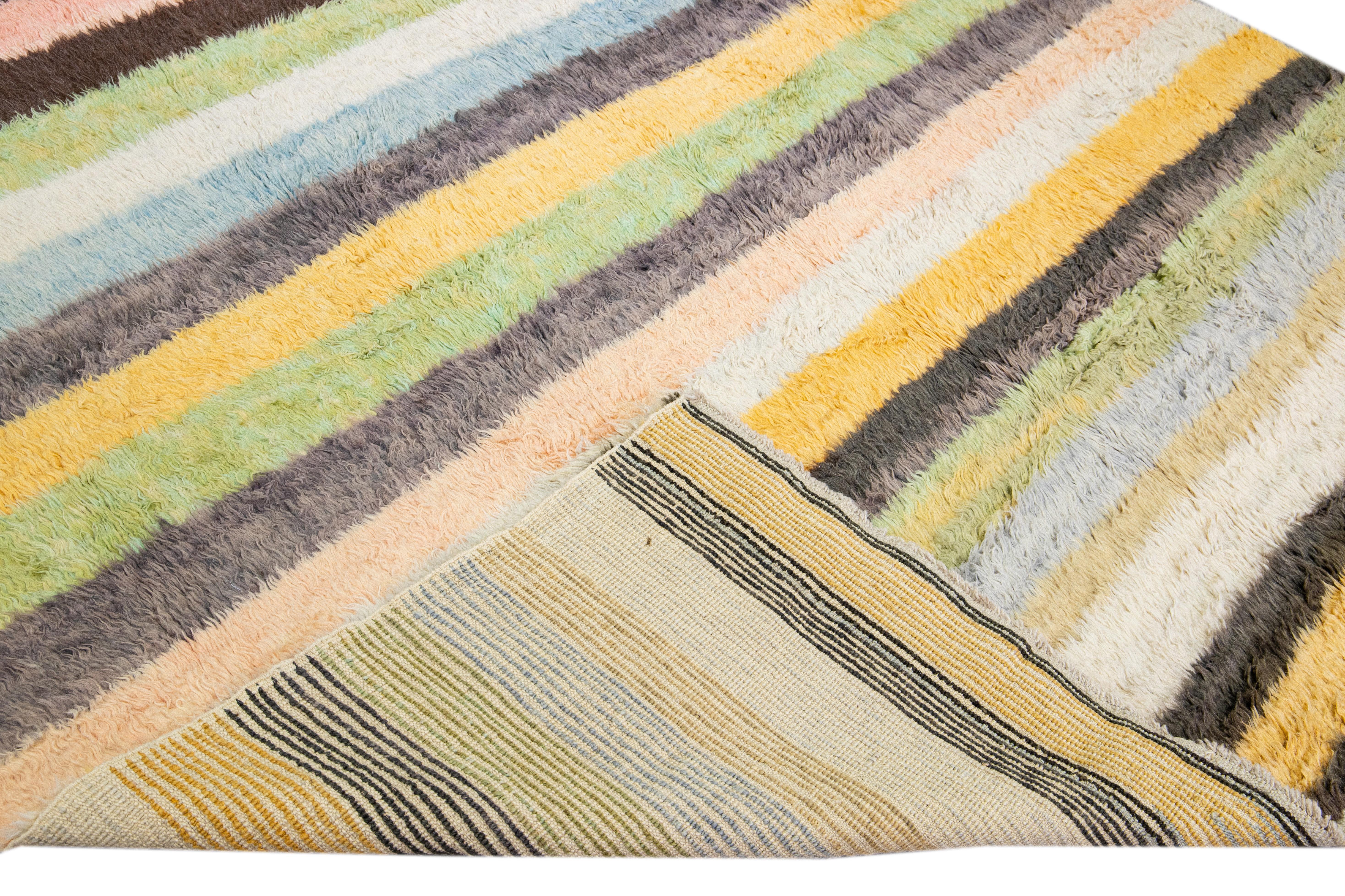 Beautiful modern Tulu hand-knotted wool rug with a multicolor field. This Tulu rug has a gorgeous all-over striped design. 

This rug measures: 9'3