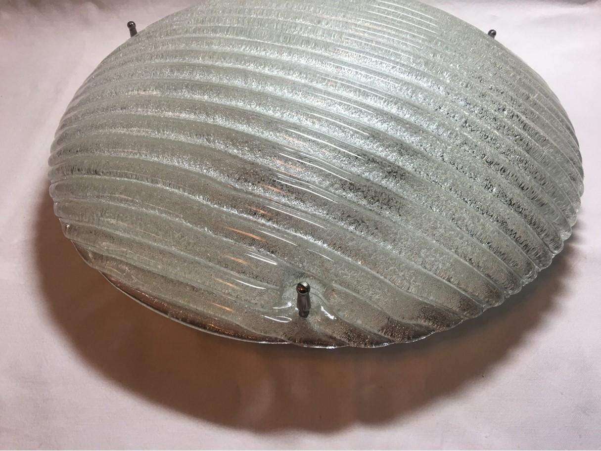 Round flat Murano ice glass flush mount with nice looking rows of recessed striping from 1960s Italy. The striping effect enhances the beauty of the flush mount, as well as the uniqueness of the lighting effect. The fixture requires two European E26