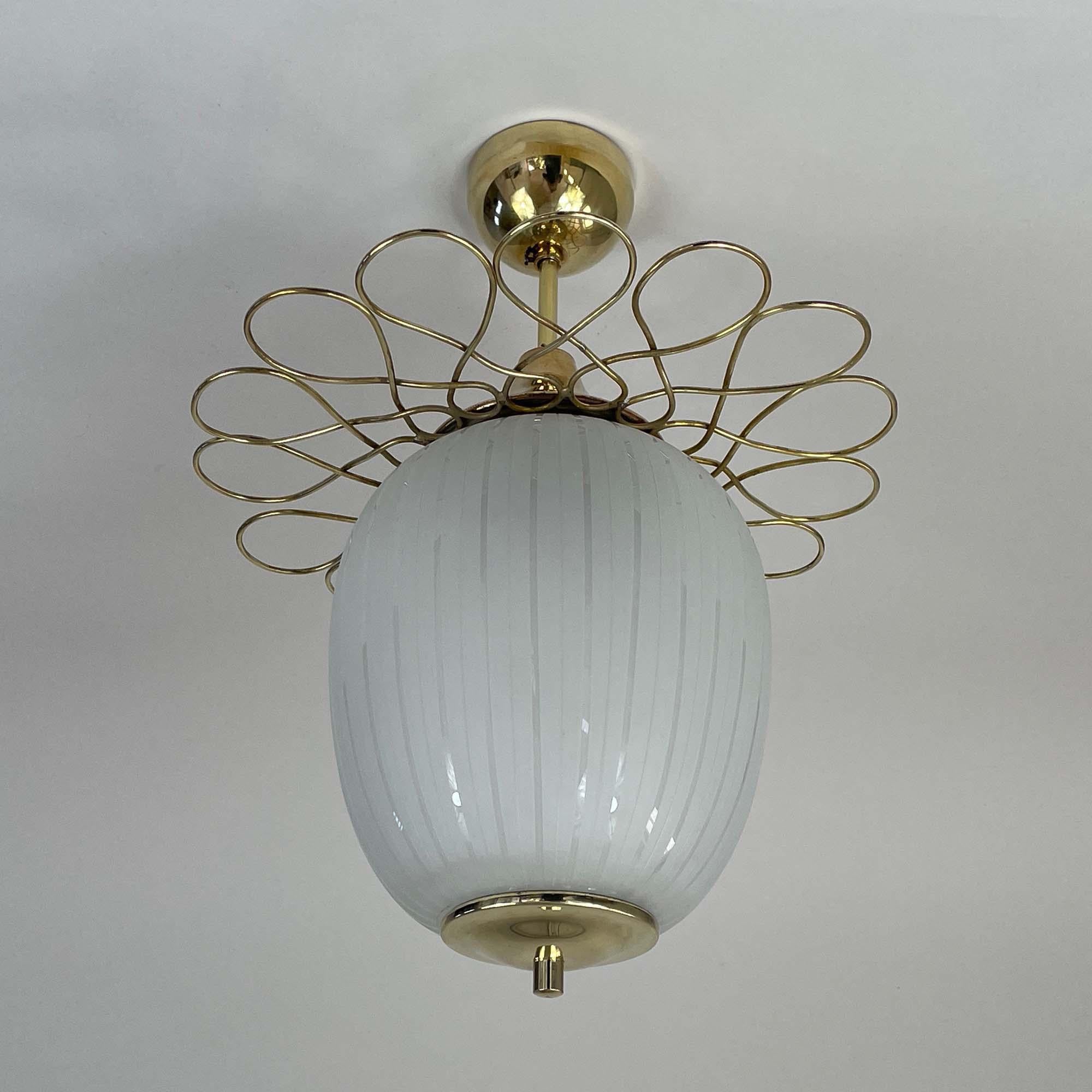 This elegant semi flush mount was designed and manufactured in Finland in the late 1940s. It features a striped and partly satinated opaline glass oval lamp shade and brass hardware.

Total height is 17.3
