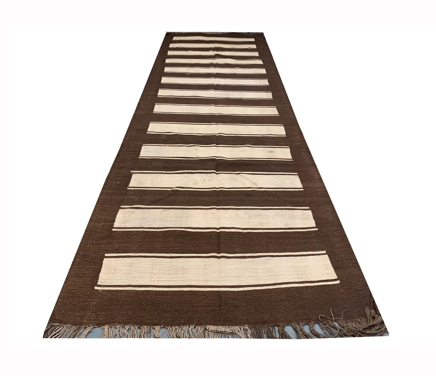 This fine hand woven wool area rug was woven in Afghanistan in 1900. The central design has been woven with a simple stripe design with a brown and cream colour palette. Both the colour and design in this piece make it the perfect accent piece. This
