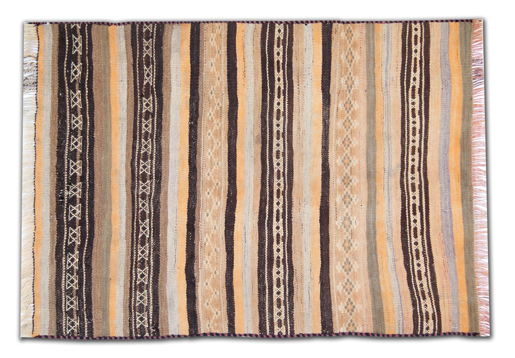 This fine wool rug is a handwoven vintage Kilim woven in Afghanistan in the 1960s. The central design features a simple rustic stripe design woven win beige, cream brown and yellow accent colours. Bold and beautiful this wool rug is sure to make the