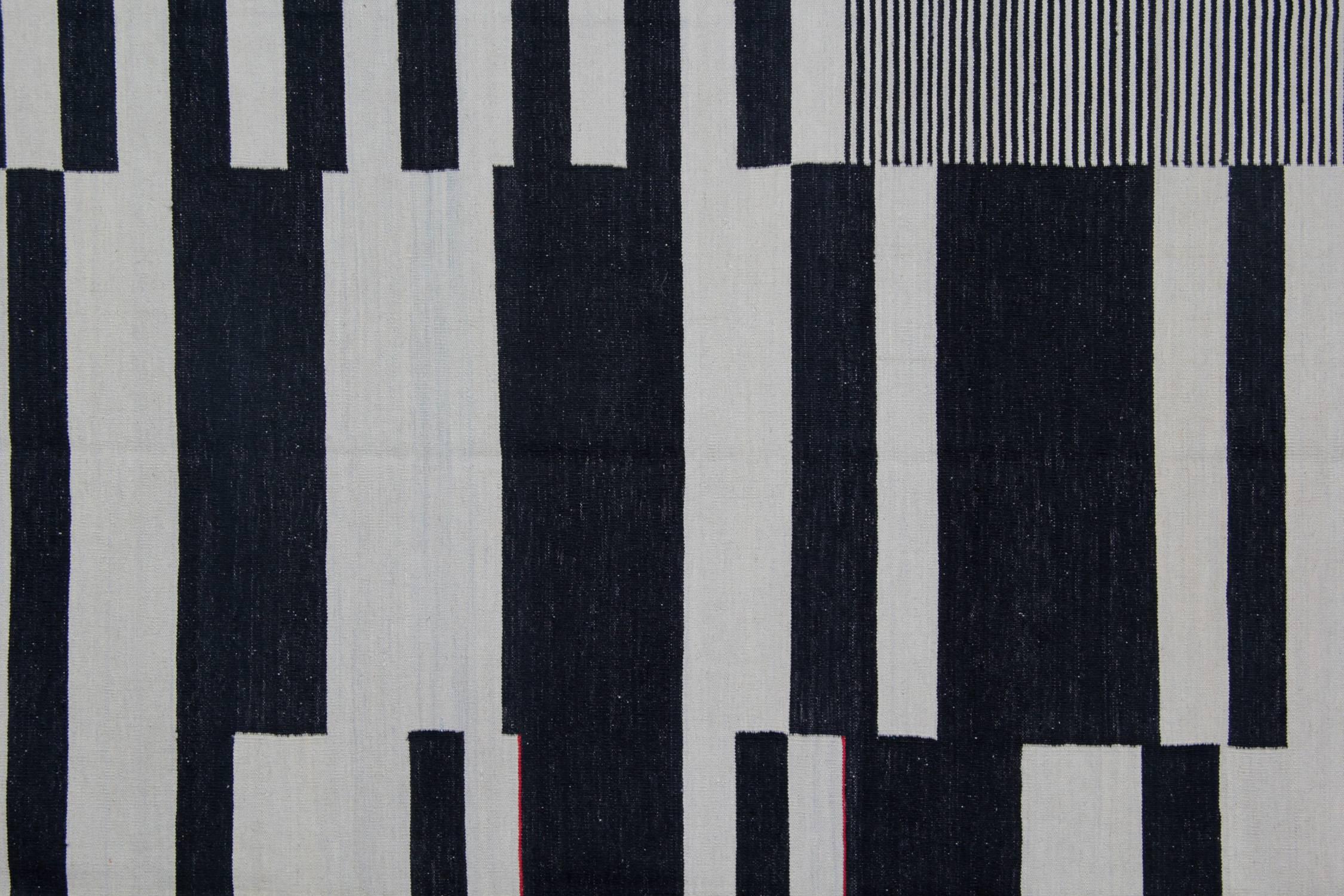 These striped wool rugs derive from Afghanistan. It is entirely handwoven rug with the best wool and cotton. Only organic dyes have been used for the production of this flat-woven rug. This striped rug shows a varied palette, including black and