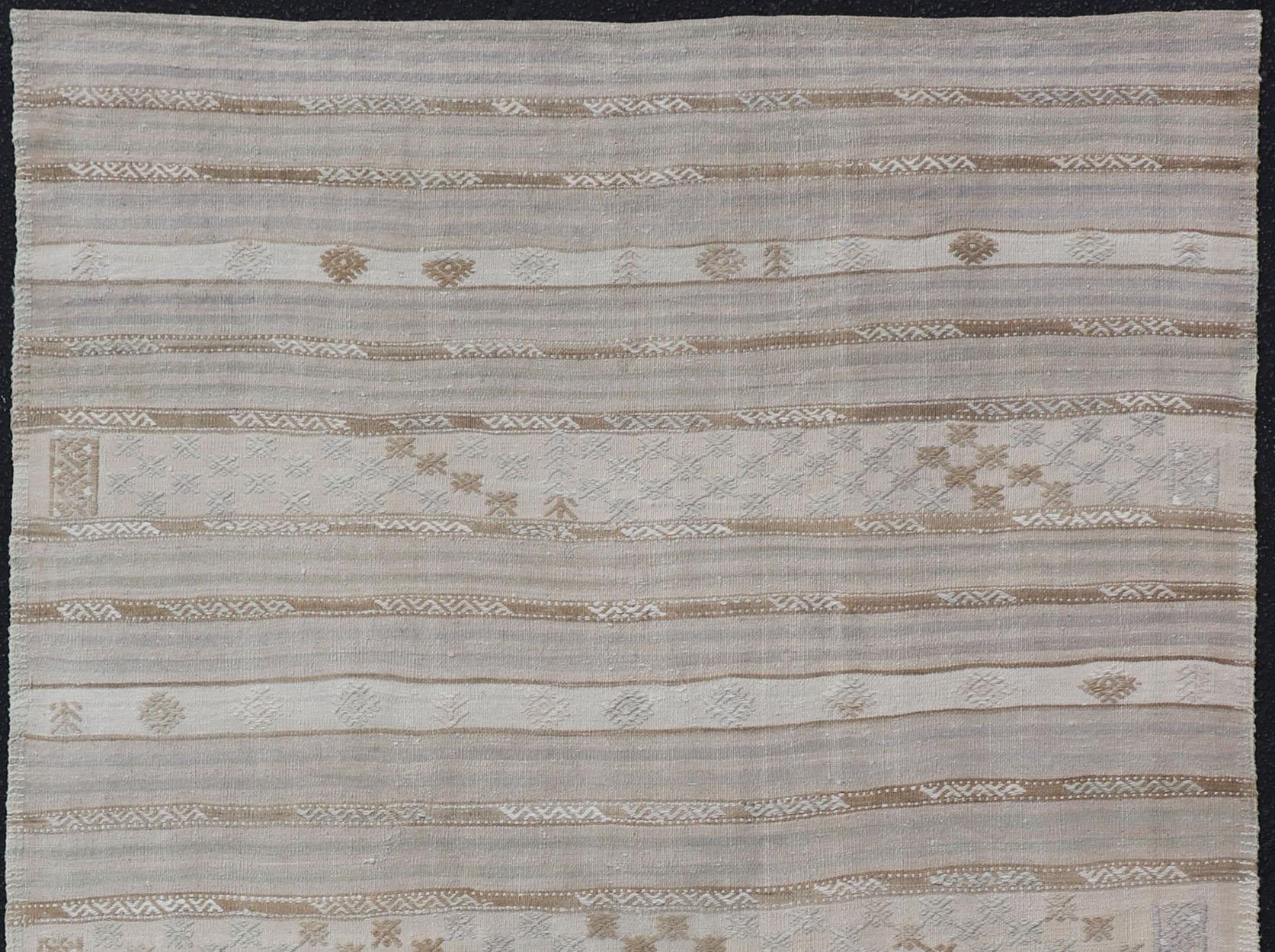 Turkish Kilim vintage carpet in light taupe, pale lavender, light brown, light gray and Cream, rug EN-179780, country of origin / type: Turkey / Kilim , circa 1950

This Kilim rug from Turkey features a striped design of various geometric patterns