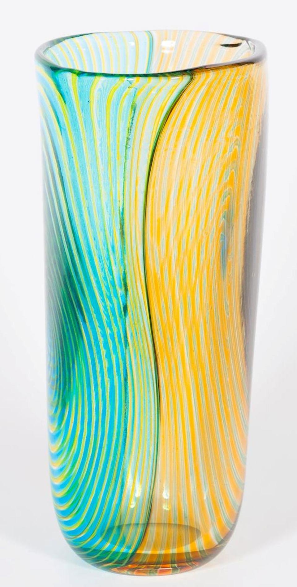 Vase rayé en verre soufflé de Murano vert orange et bleu clair, années 1990, Italie.
Il s'agit d'un vase rayé unique, avec des côtés bicolores et des rayures à l'intérieur de la technique soufflée. La moitié est sur une base de couleur orange, et