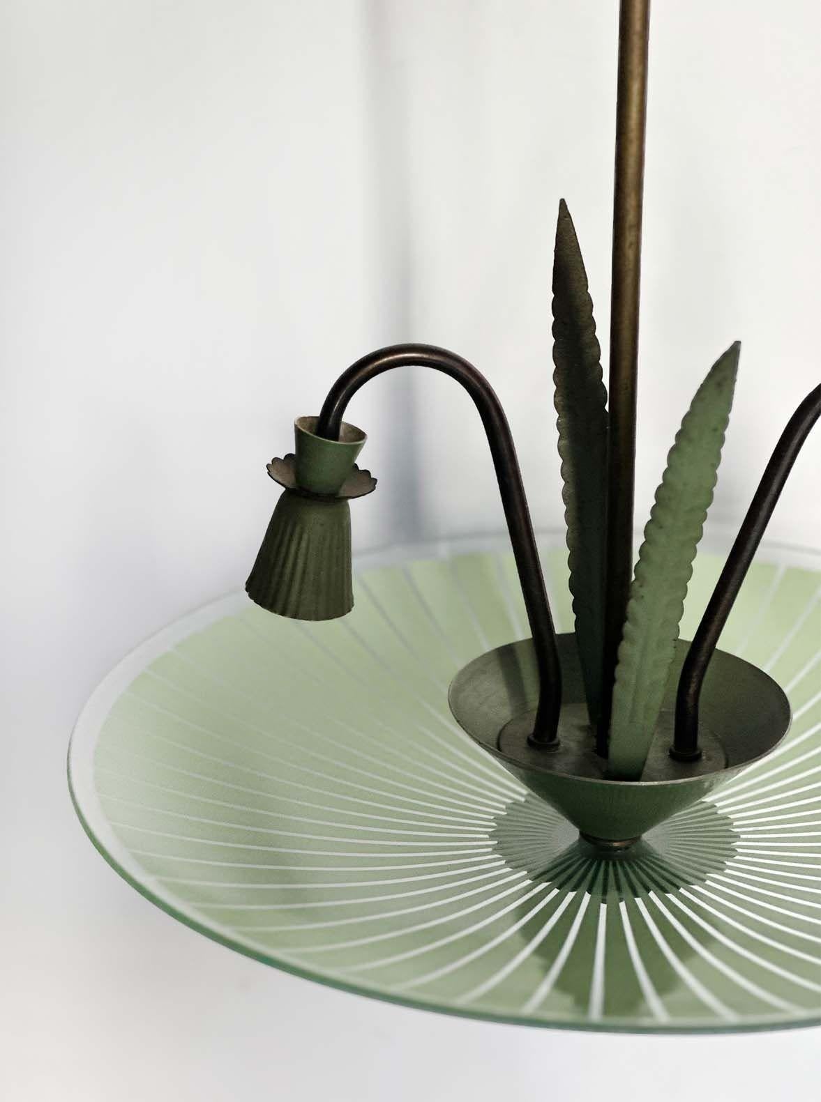 Vintage Murano glass and metal pendant made in Italy, c. 1960's by Stilnovo. This fixture stands out due to its beautiful green tones and striped design all around, as well as a cattail design in the center of the piece. Includes two candelabra