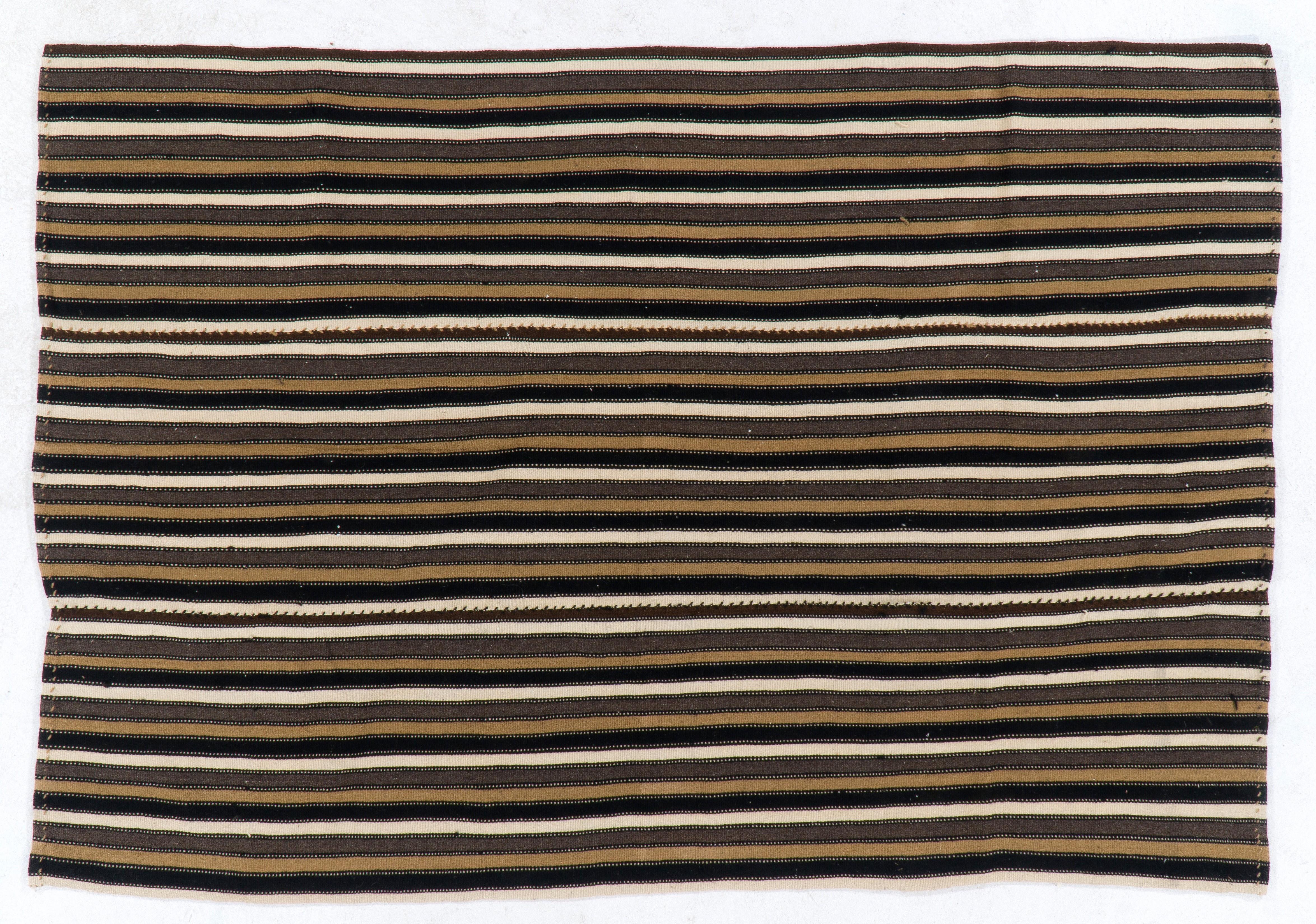 This beautiful and simple flat-woven rug is made of wool in brown, taupe, ivory and black colors. It was woven by semi nomadic villagers in Central Anatolia for domestic use. Ca 1960-1970