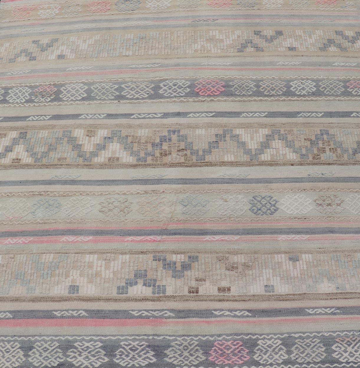  Rayures et broderies Kilim turc à tissage plat dans diverses couleurs sourdes. Keivan Woven Arts / tapis EN-15178, pays d'origine / type : Turquie / Kilim, circa 1950

Mesures : 5'4 x 5'10 

Ce tapis Rug & Kilim de Turquie présente un design rayé