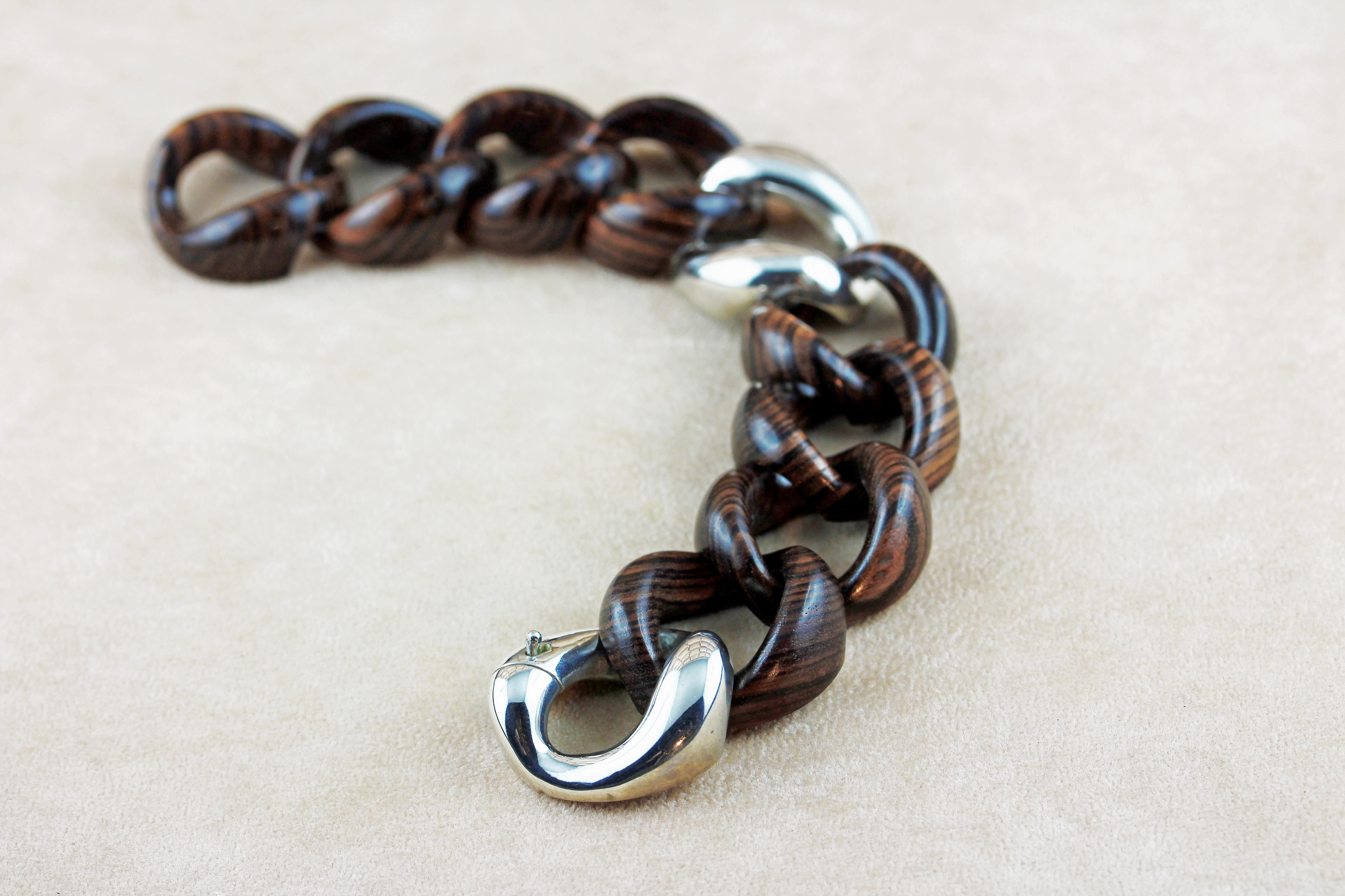 In this elegant groumette bracelet brown stripes wooden rings are embellish in the middle by a ring in the middle creating a contemporary allure.
The clasp and  in silver 925. 
 
Dimensions:
                     21,5cm x 3 cm circa

Weight:
        