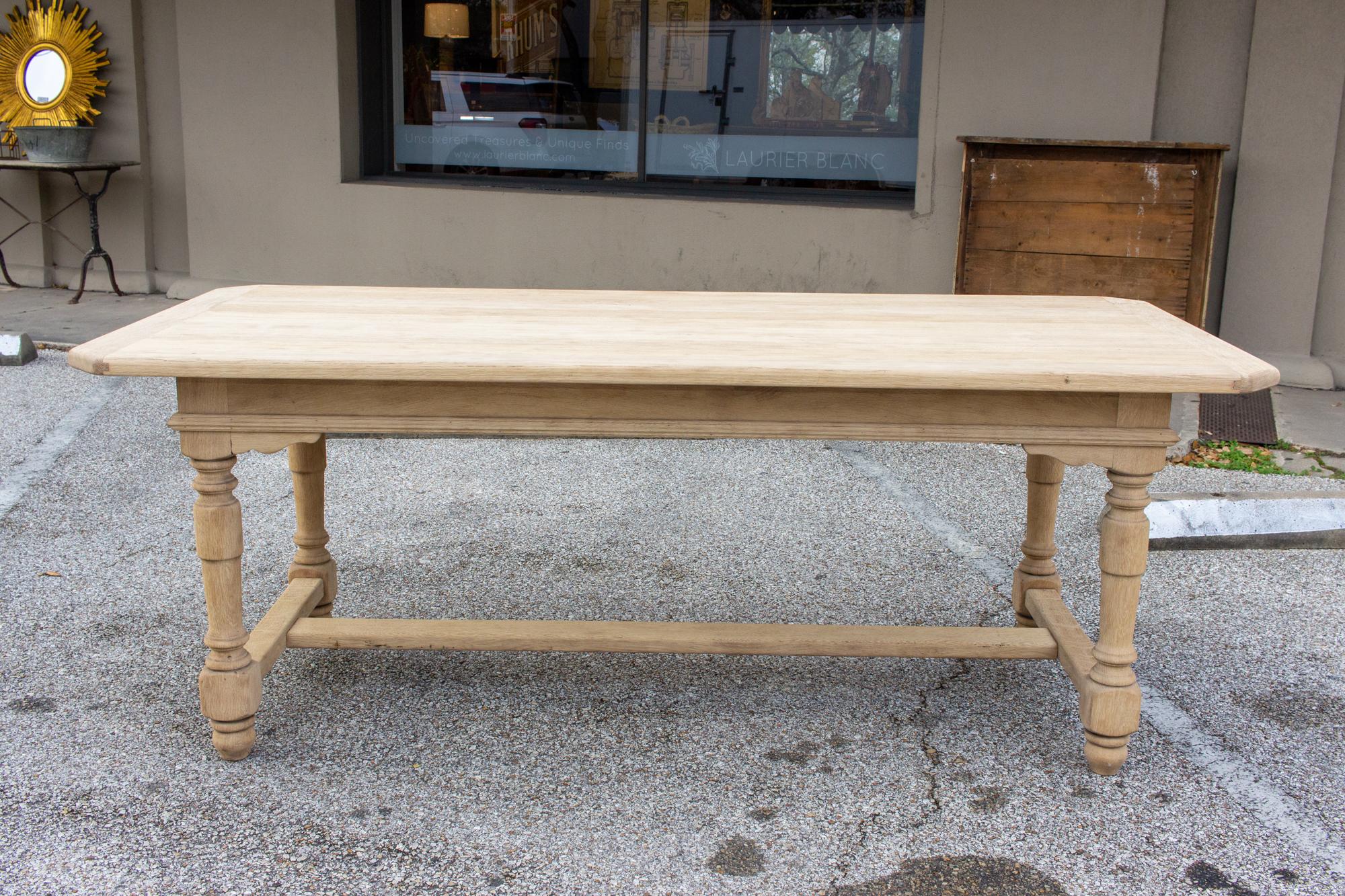 This antique French oak table has turned details in the legs, with hand carved accents in the apron and an I-shaped stretcher at the base. There are carved details in the apron, where the legs meet, at each corner. The top itself has a rounded edge