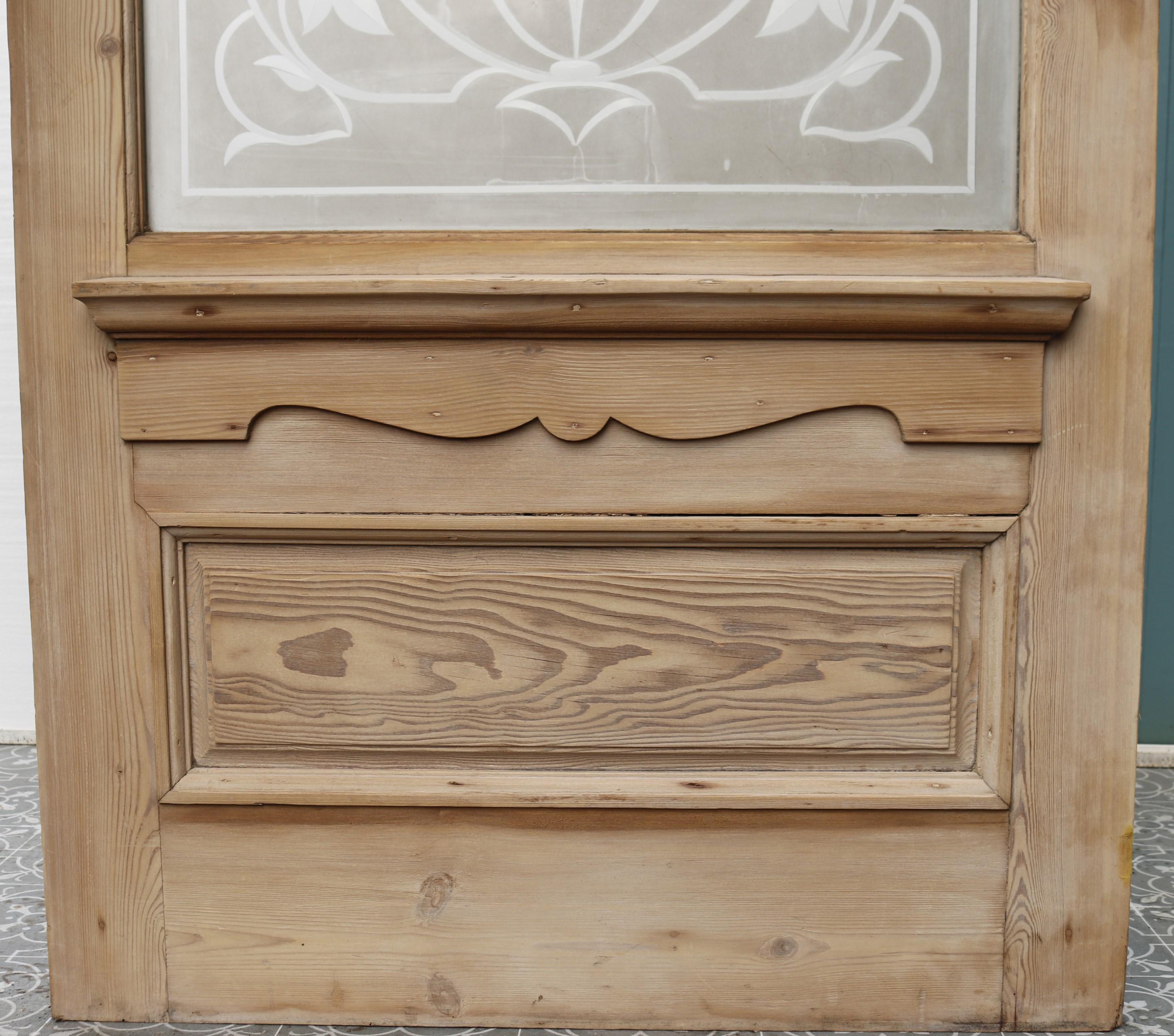 A salvaged pine front door with complete etched glass panel and a sanded finish ready for waxing or painting.

This is suitable for use as a front door or internally.