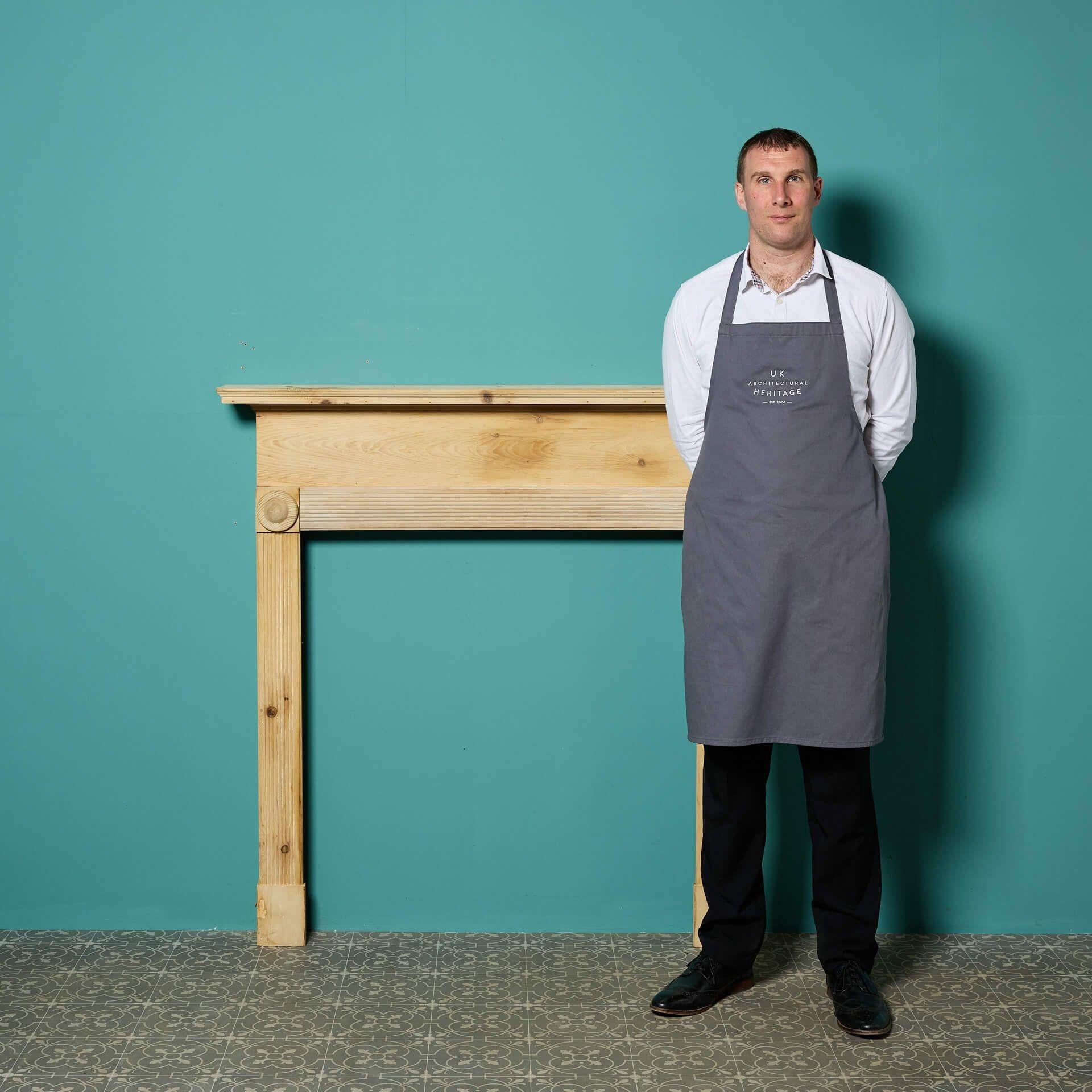 Though this antique English fireplace dates from the cusp of the 20th century, its design draws influence from bullseye fireplaces of the earlier Regency and Georgian periods. Crafted in pine, it is stripped, sanded and ready for finishing in a
