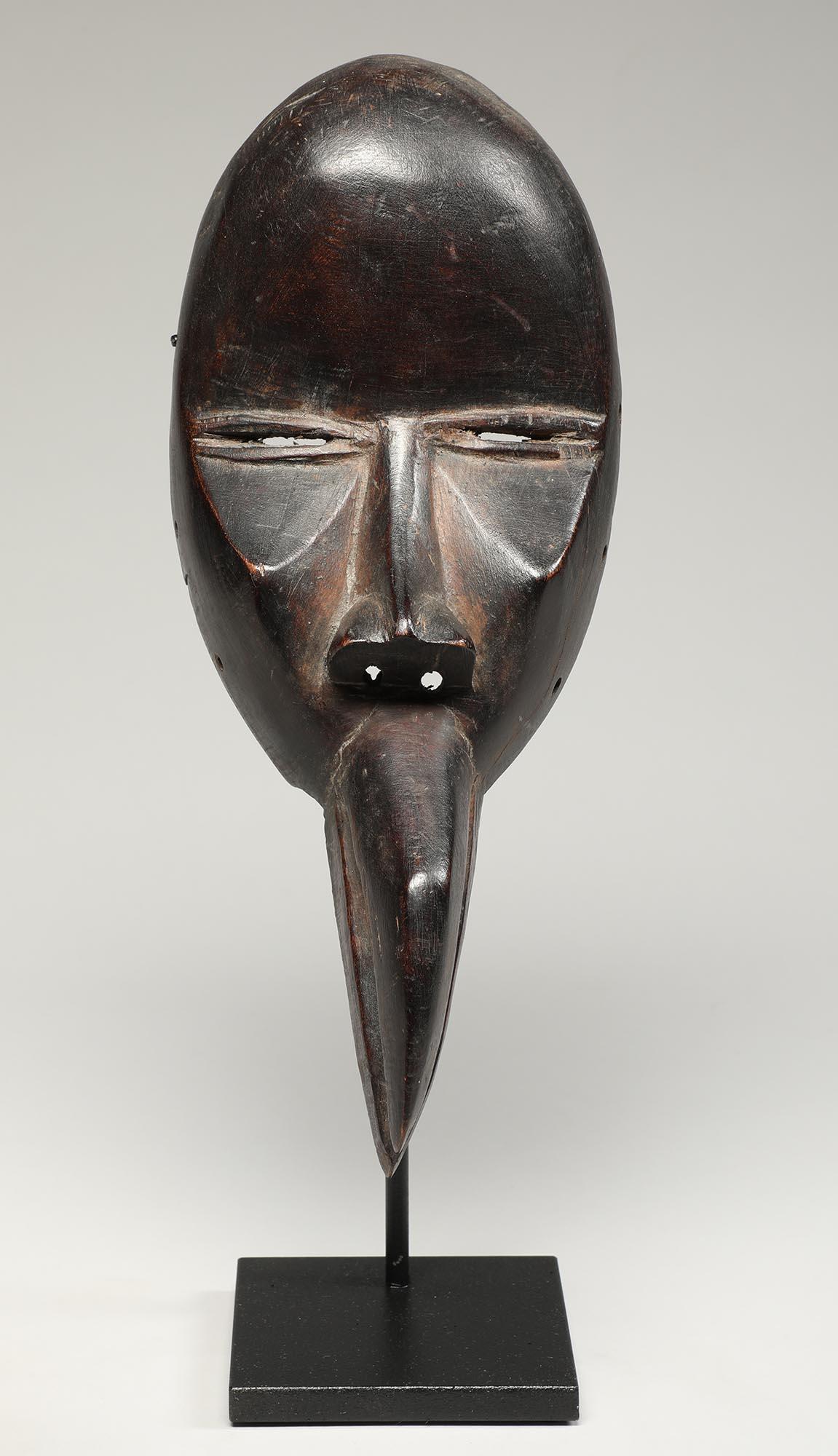 A strong cubist Dan mask from Liberia in West Africa. High carved cheek bones and narrow slit eyes above the curved bird beak. Representing a fusion of animal and bird. Ex- private collection NY from 1980s, ex private collection, California, early