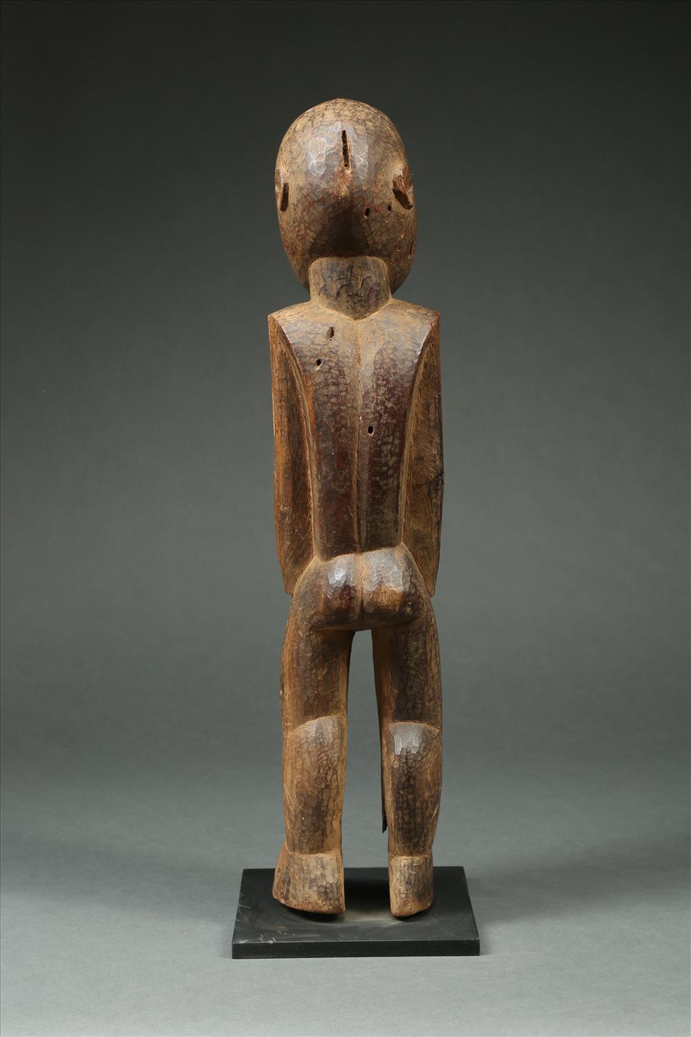 Finely carved large geometric figure from the Lobi, of Ghana and Burkina Faso, dating from the early to mid-20th century. It has a captivating gaze. Carved from very hard wood with small adze marks creating a vibrant texture. Some insect damage to