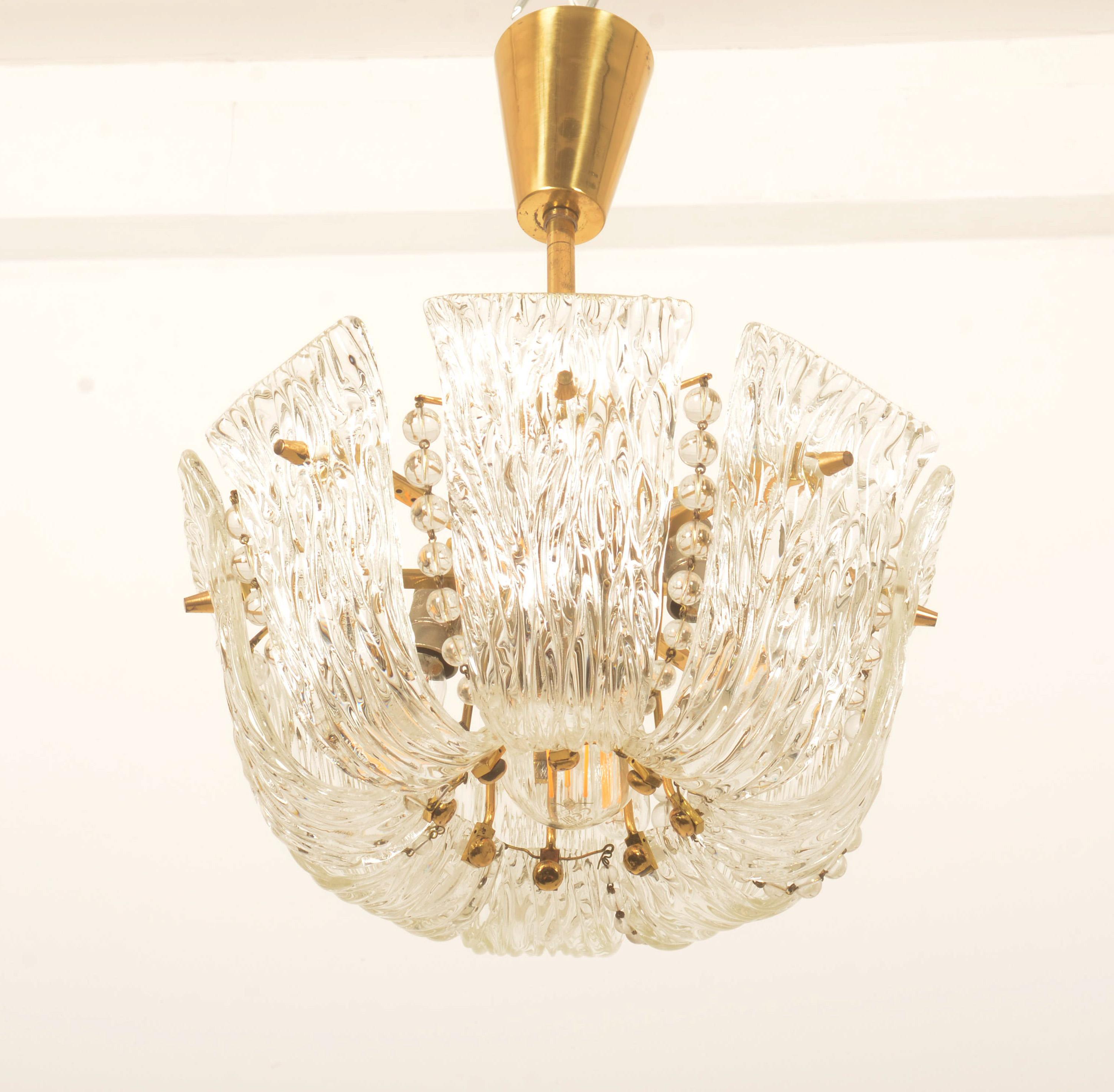 Brass frame with eight structured glass elements and glass pearls fitted with four E14 sockets and one E27 sockets. Manufactured by J.T. Kalmar in the early 1950s.