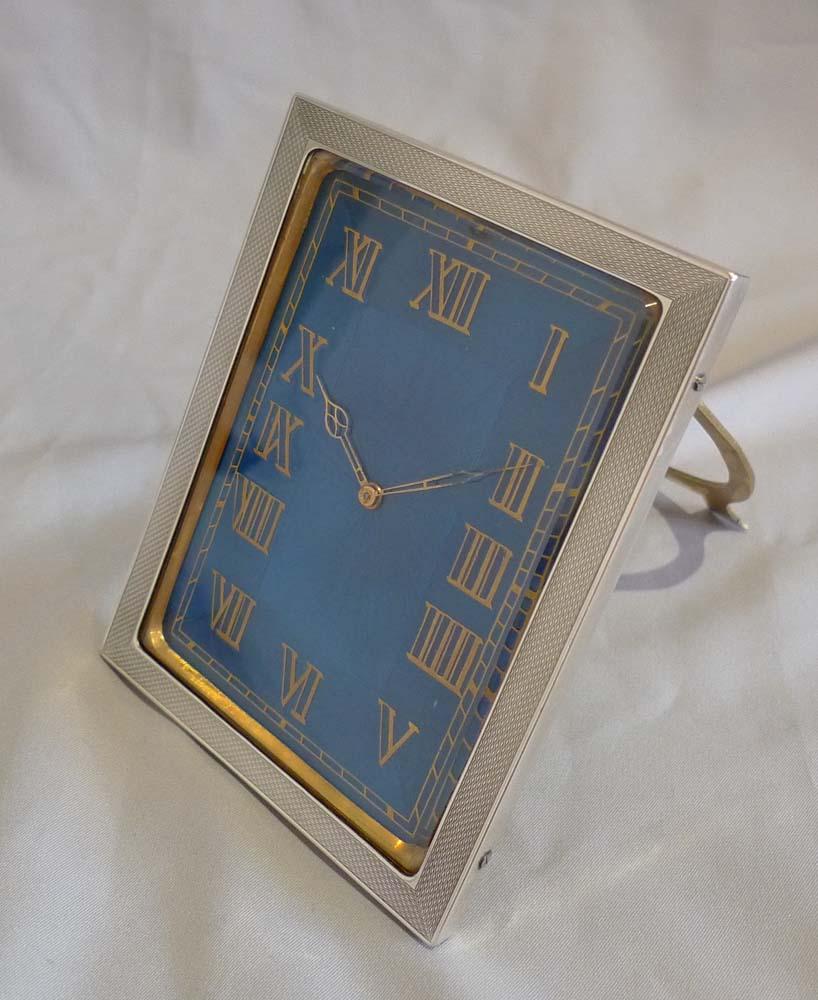 A very heavy and attractive engine turned silver strut clock with a fine dial of petrol blue enamel over engine turning. Roman numerals picked out in gold. Fine gilded hands. Eight day movement. Numbered silver case and brass back No. 29684.