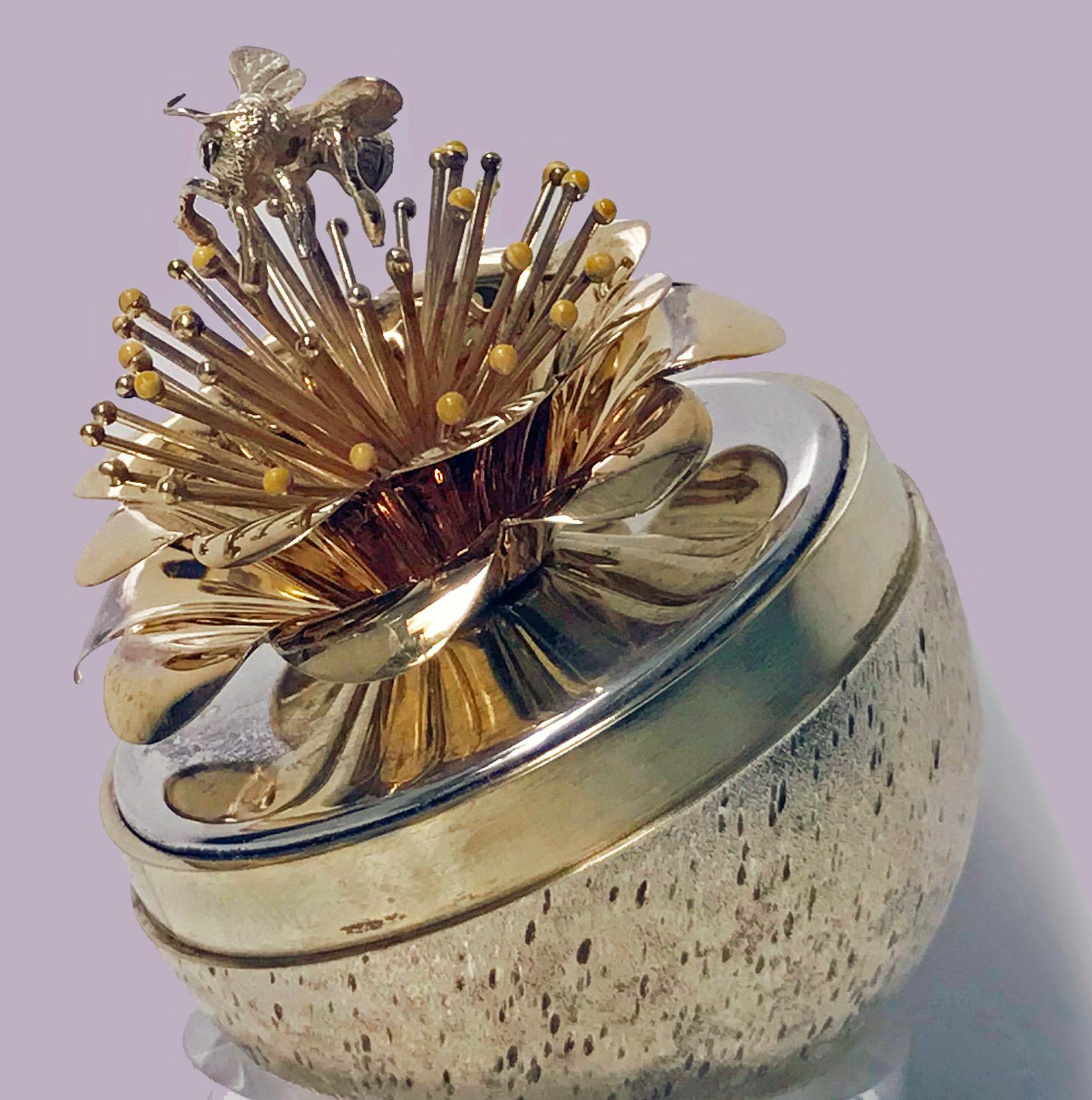 Stuart Devlin, silver parcel-gilt and enamel honey bee novelty surprise egg, London, 1981 limited edition 19/229, in its original box. The egg depicting a honey bee surmounted on a flower with yellow and gold buds. Measures: Height 7 cm. Weight: 119